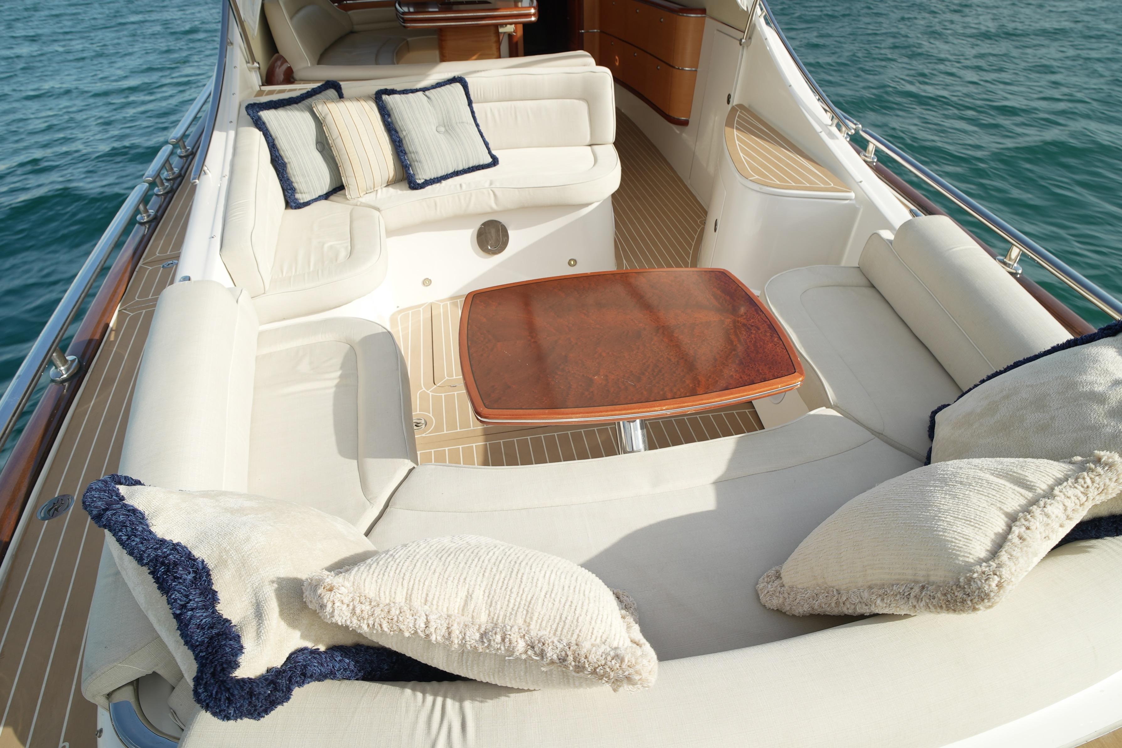 Luxurious seating area on a 2013 Zeelander Z44 yacht with plush cushions and wooden table.