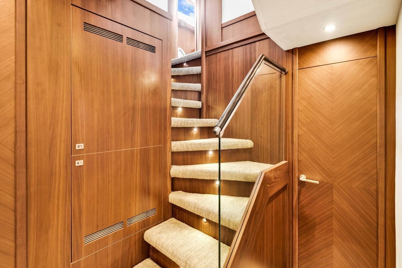 Luxurious wooden staircase with carpeted steps on a 2012 Princess 85 yacht.