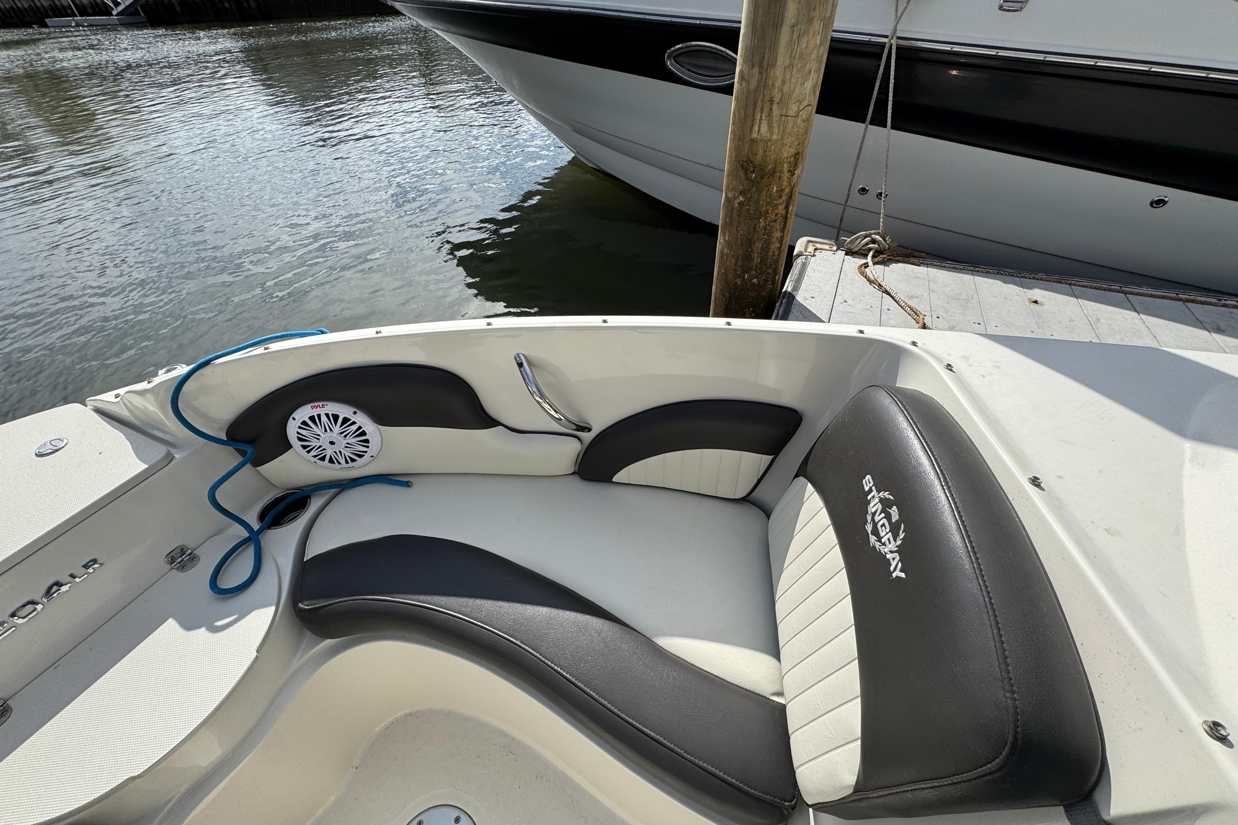 2019 Stingray 204 LR boat interior with black and white seating, docked by water.