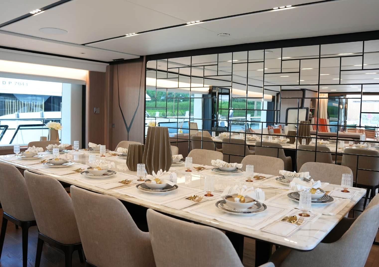 Luxurious dining area on 2025 Majesty 120 yacht, featuring elegant table settings and modern decor.