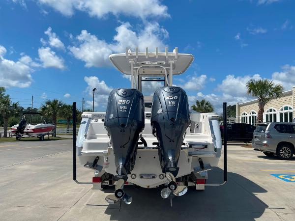 2023 Robalo R270 boat with twin 250 V6 engines, docked under a clear blue sky.
