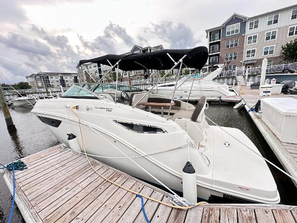 2015 Sea Ray 260 Sundancer docked at marina with canopy, residential buildings in background.