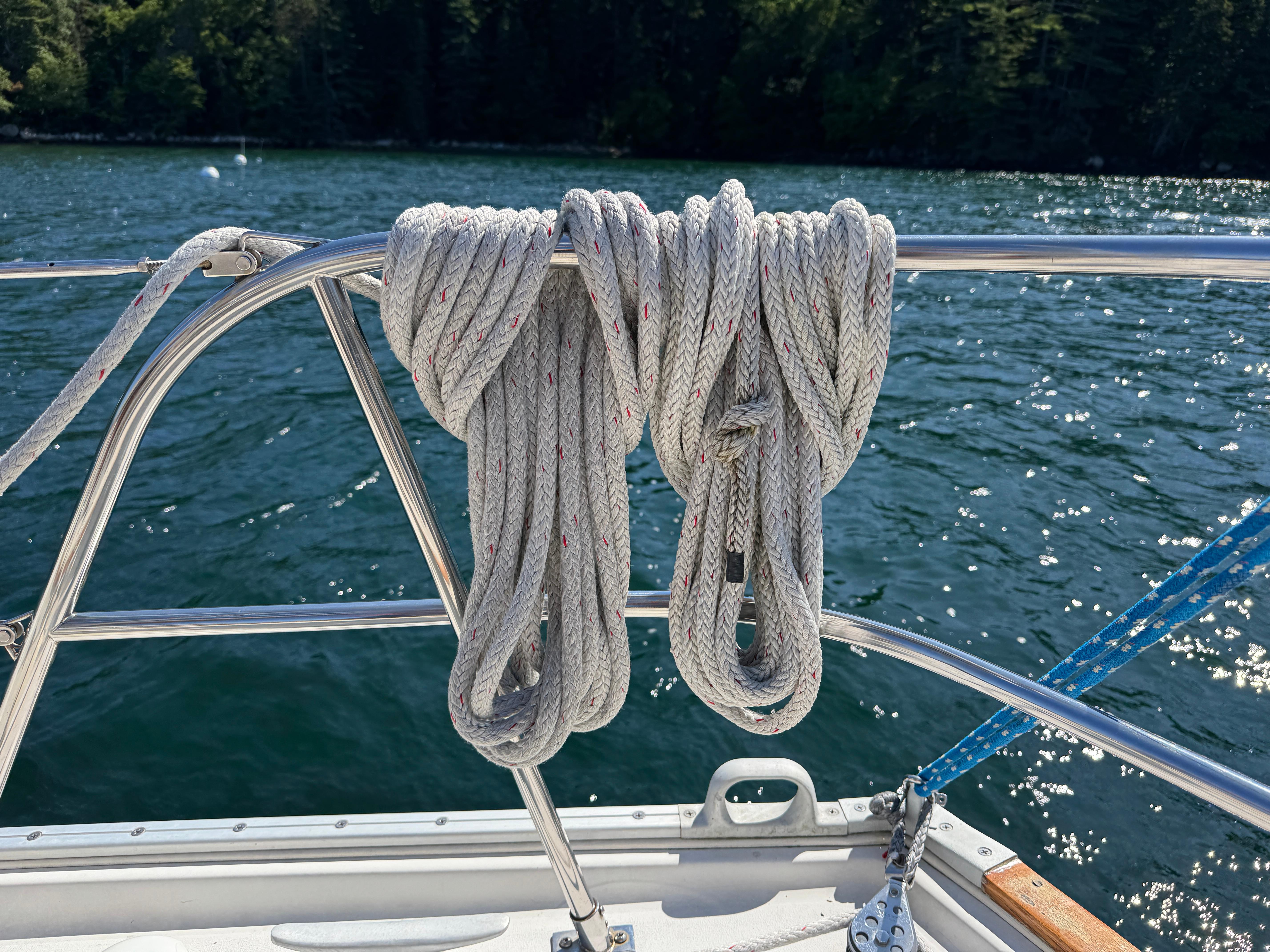 Coiled rope on 1989 Nonsuch 30 Ultra sailboat railing, with water background.