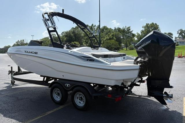 2024 Tahoe T21 boat on trailer with Mercury outboard motor, parked outdoors.