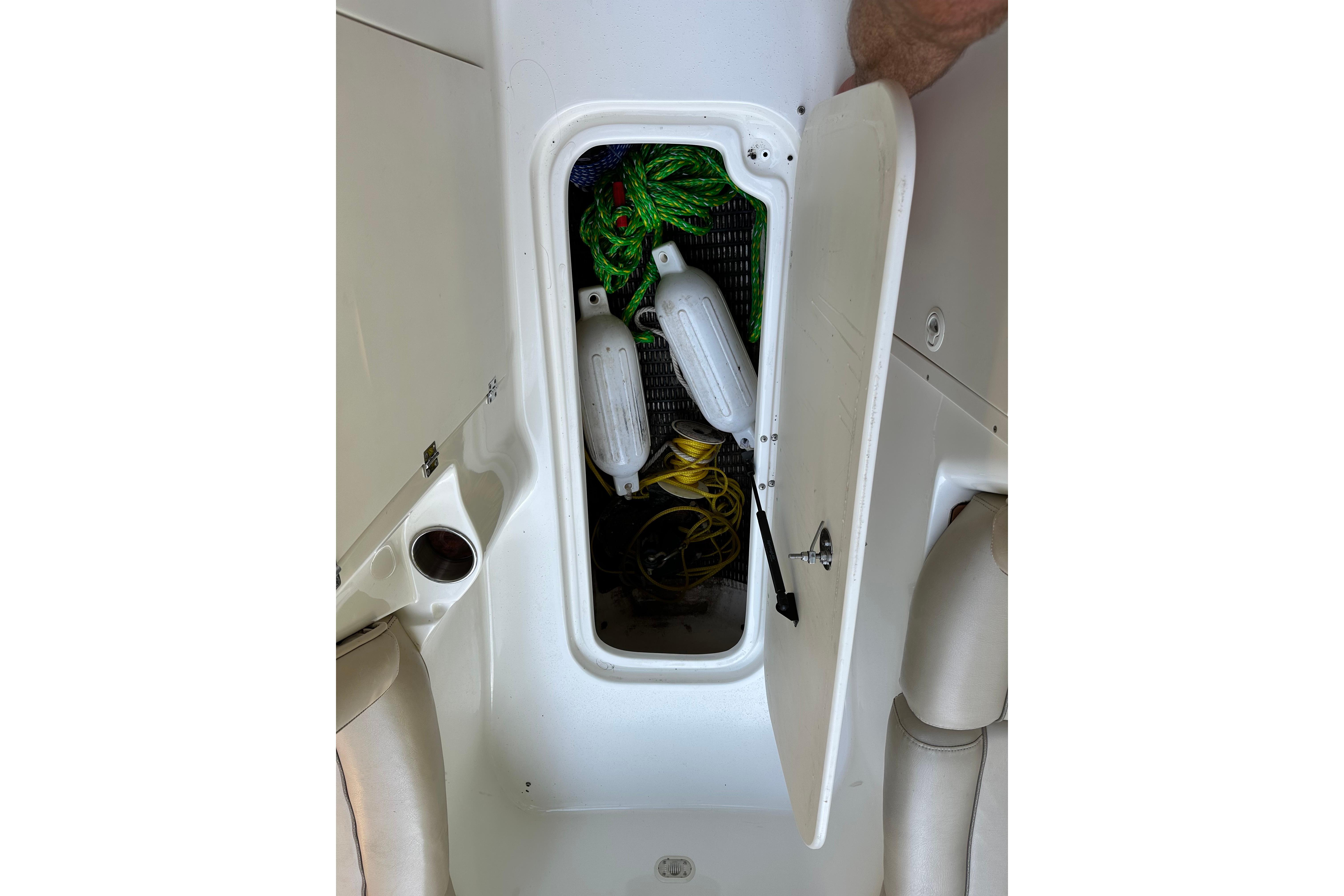 Open storage compartment on 2008 NauticStar 230 SL Sport Deck I/O boat, containing ropes and fenders.