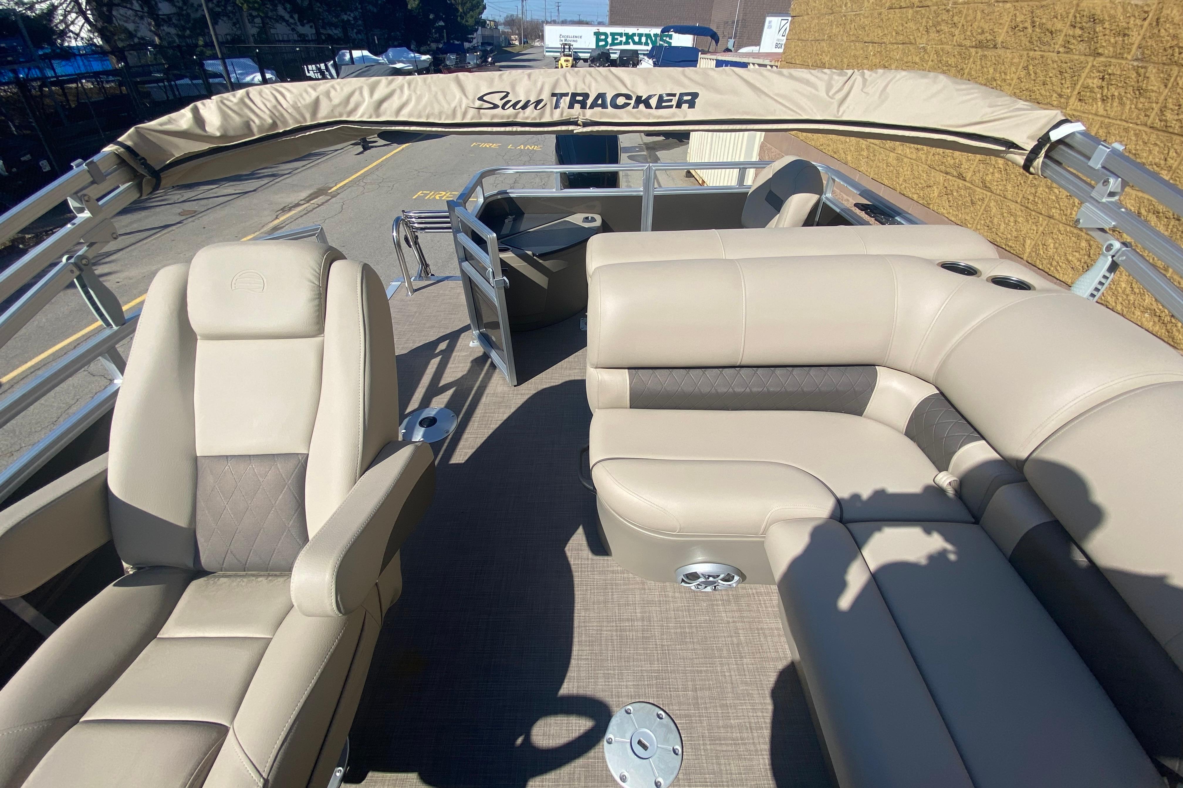 2025 Sun Tracker SportFish 20 DLX pontoon boat interior with beige seating and canopy.