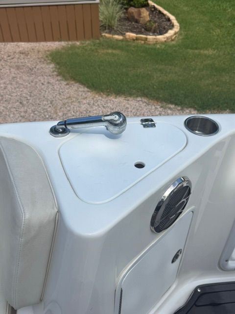 A section of the boat with a speaker, cup holder, and handle is visible.