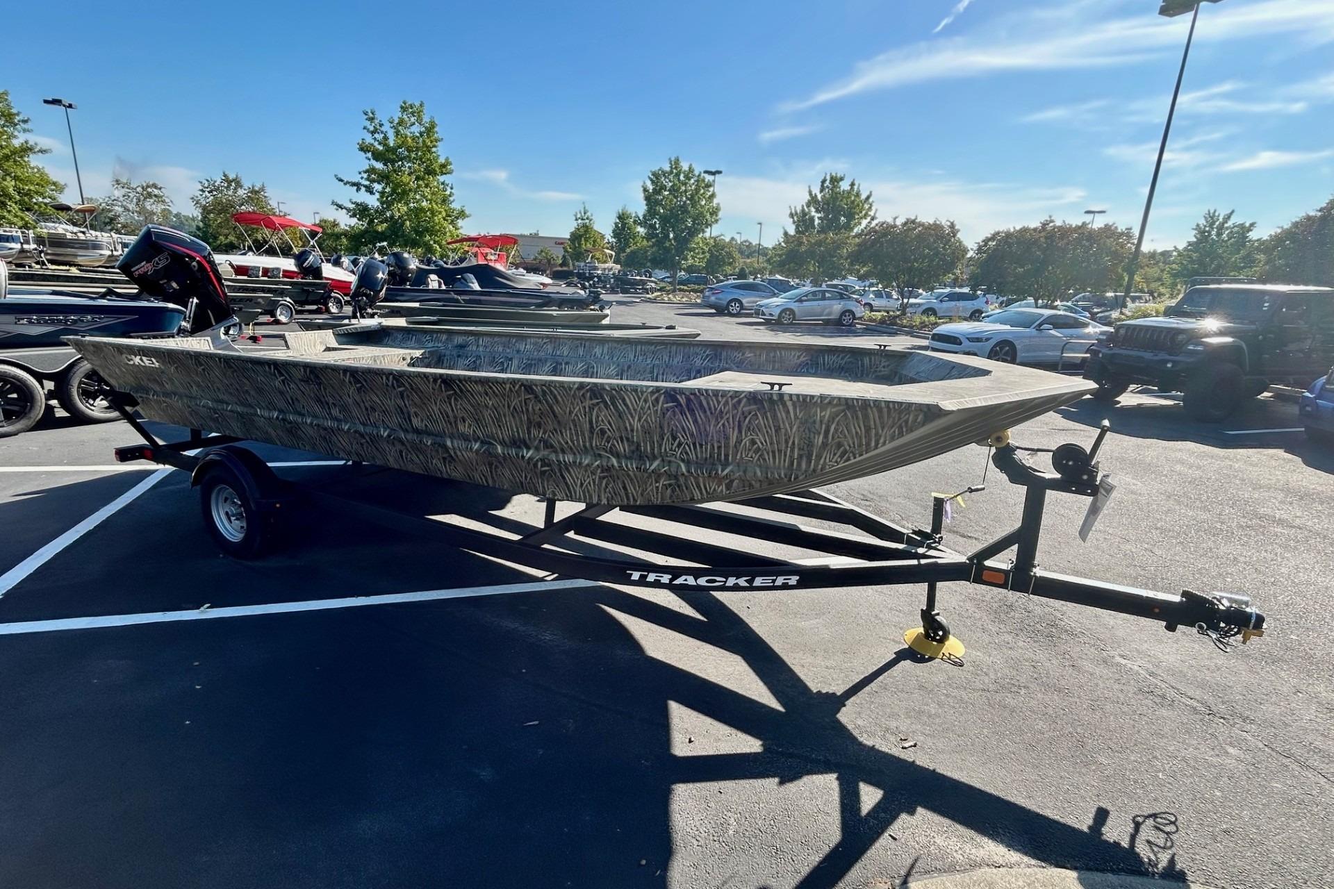 2026 Tracker Grizzly 2072 Utility boat on trailer in parking lot, sunny day.