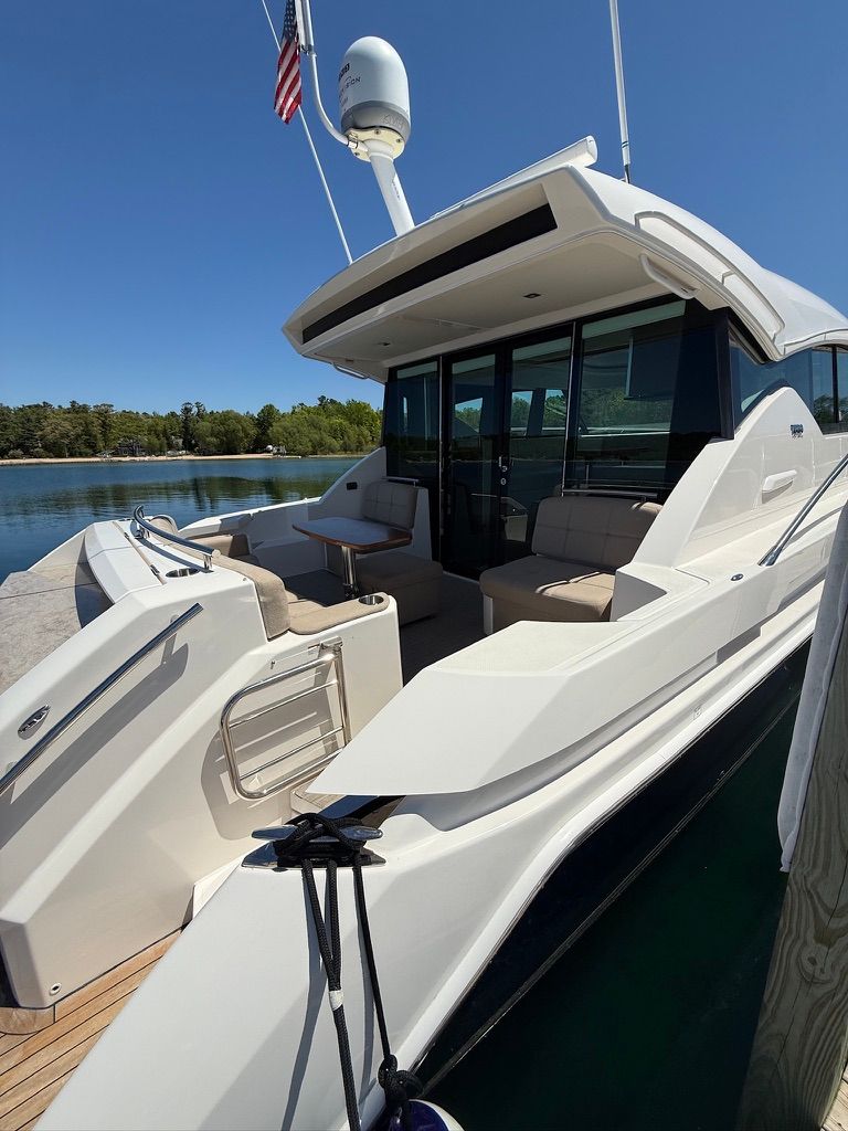 The 2017 Tiara Yachts C44 Coupe is docked in a serene setting with clear views.