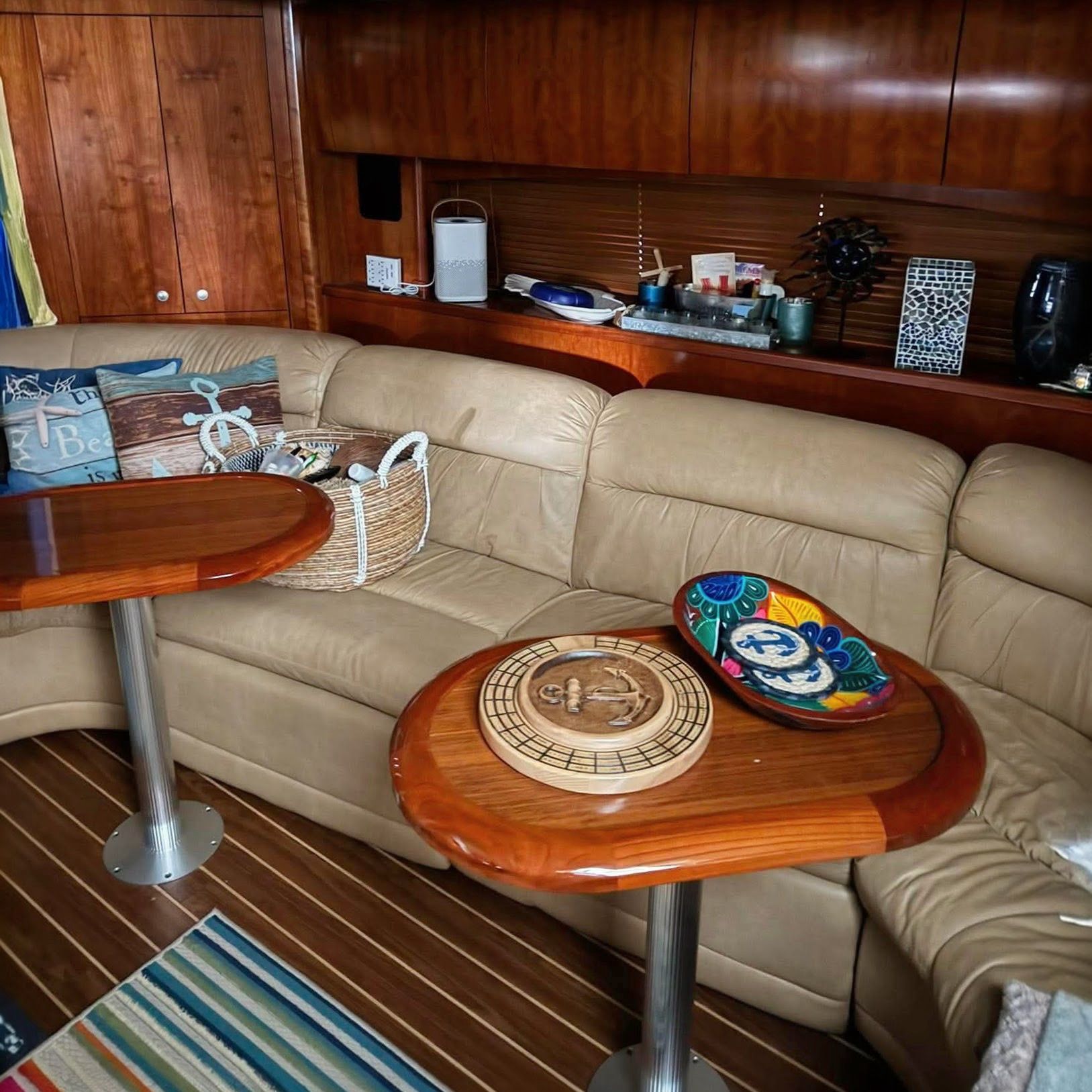 Interior of a 2009 Cruisers Yachts 520 Sports Coupe with beige sofa and wooden tables.