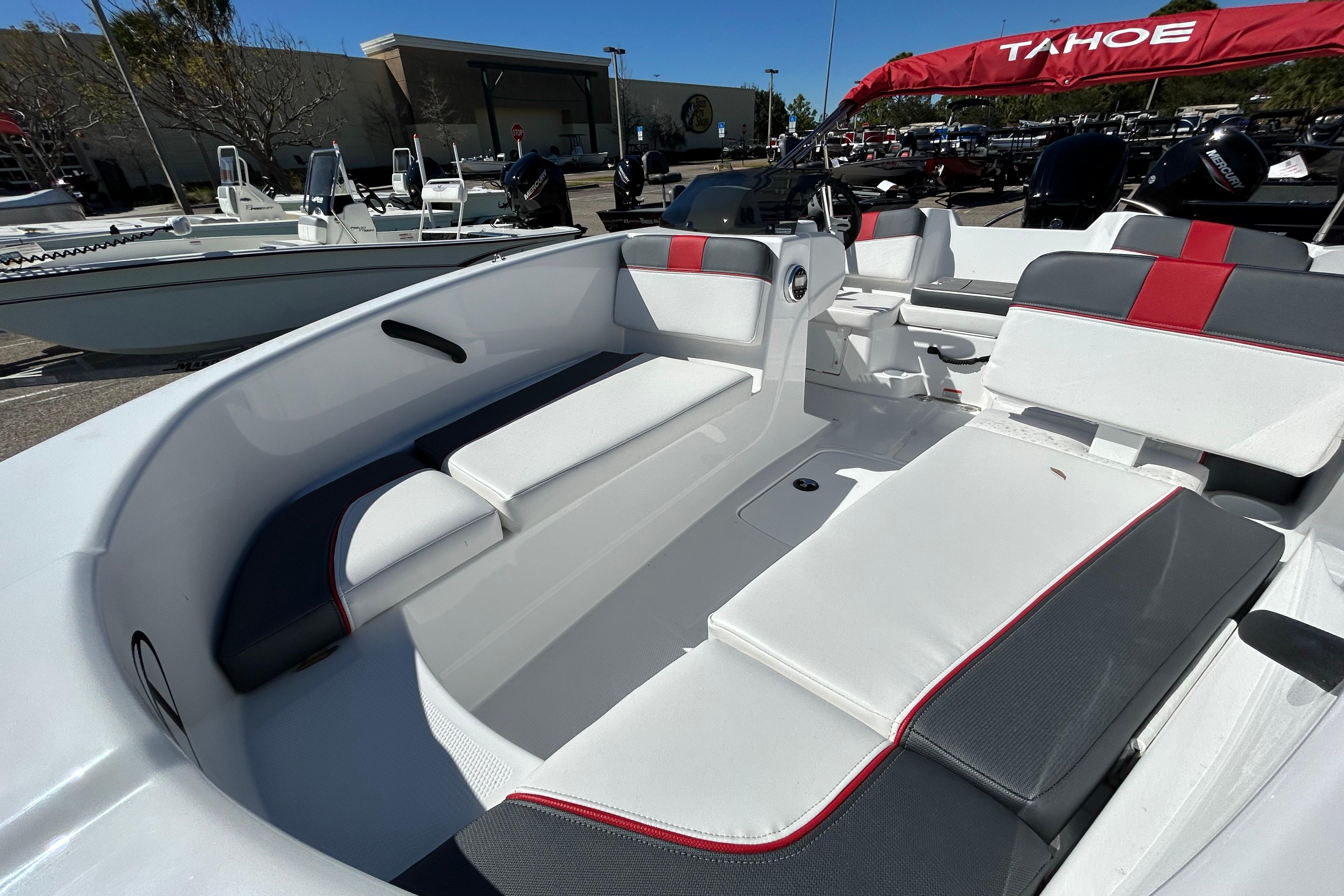 2026 Tahoe T16 boat interior with white and red seating, displayed outdoors.