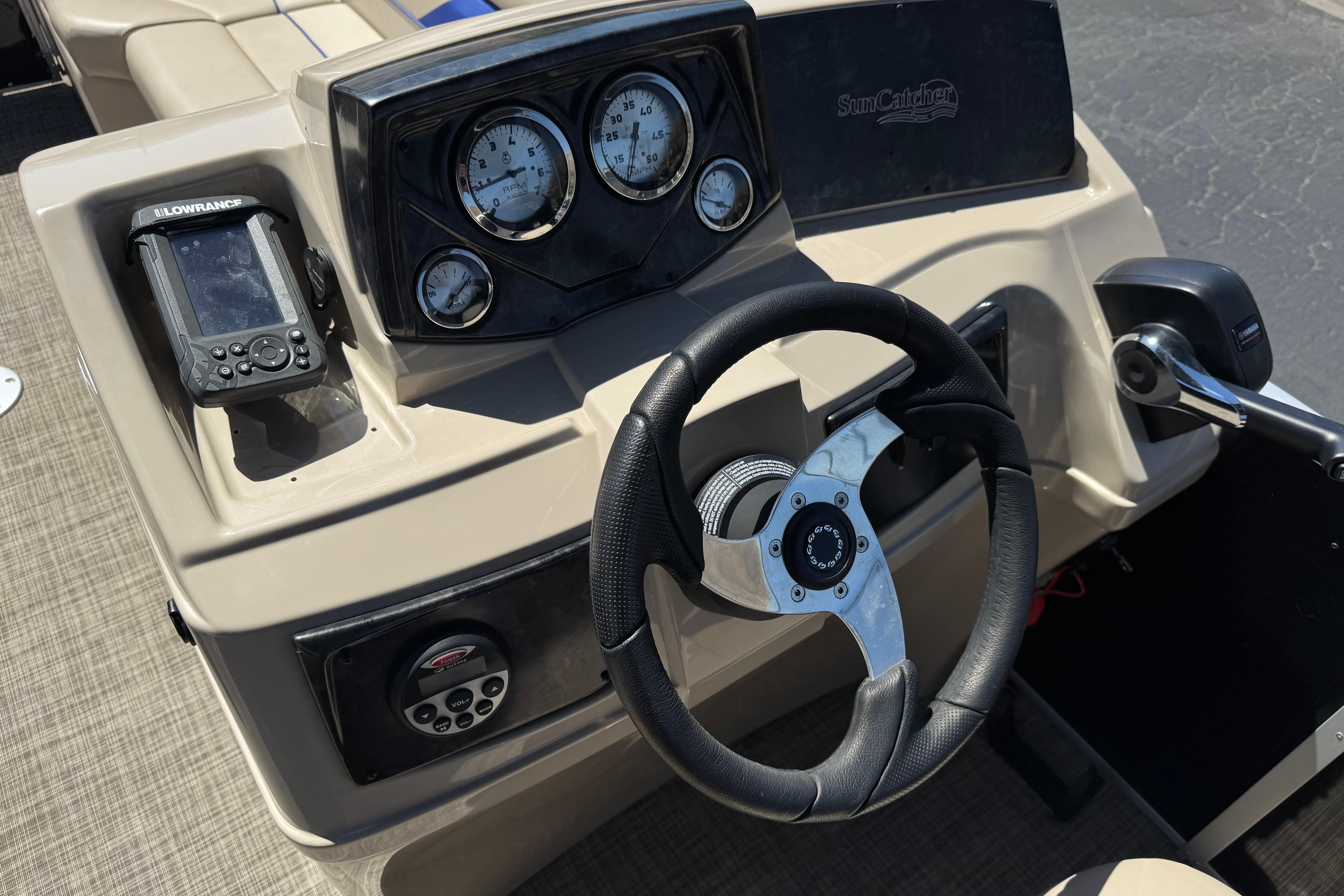 2021 SunCatcher Select 20RCX boat dashboard with steering wheel and navigation controls.