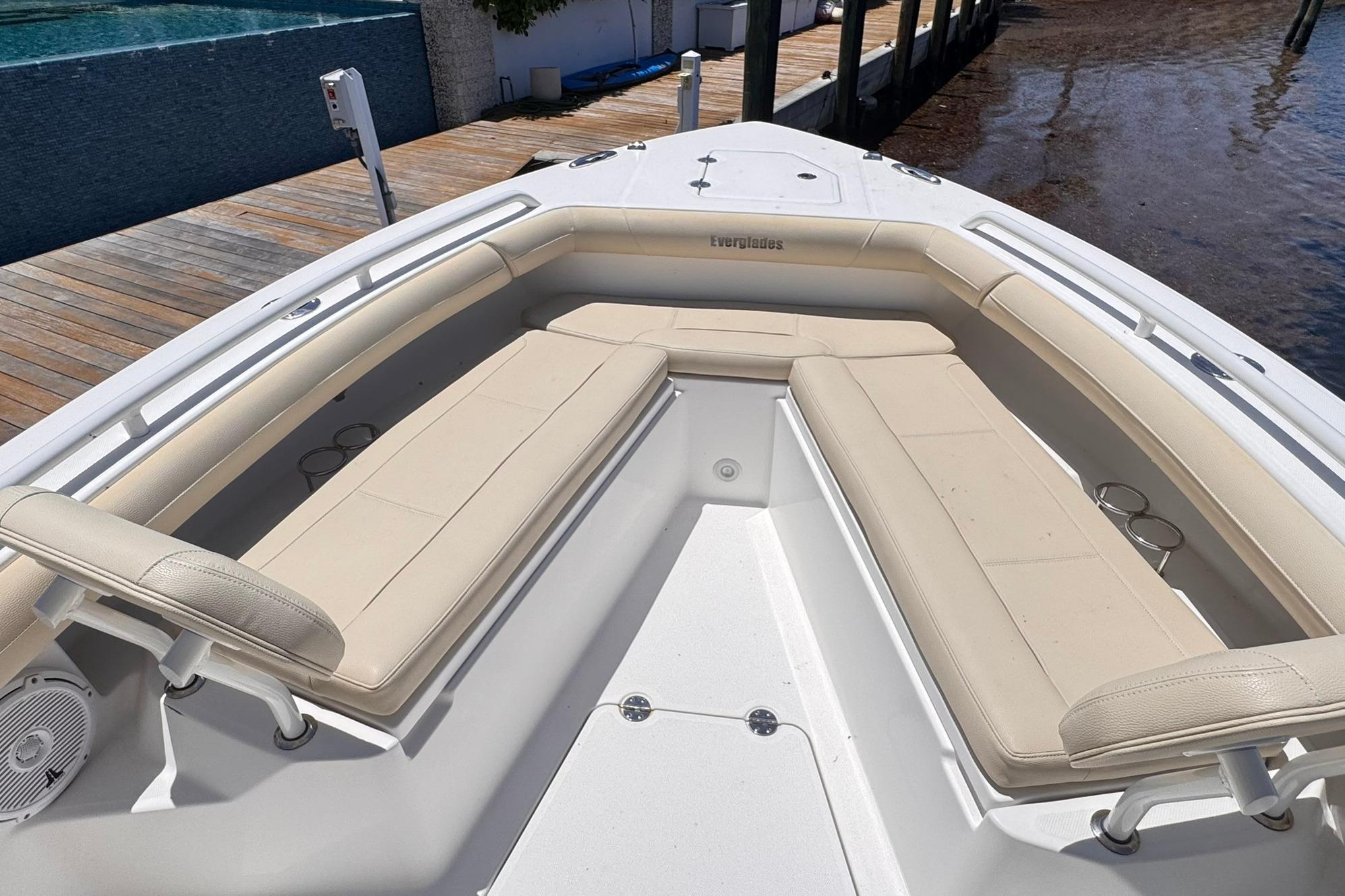 2018 Everglades 253 Center Console boat with beige seating and cup holders, docked by water.
