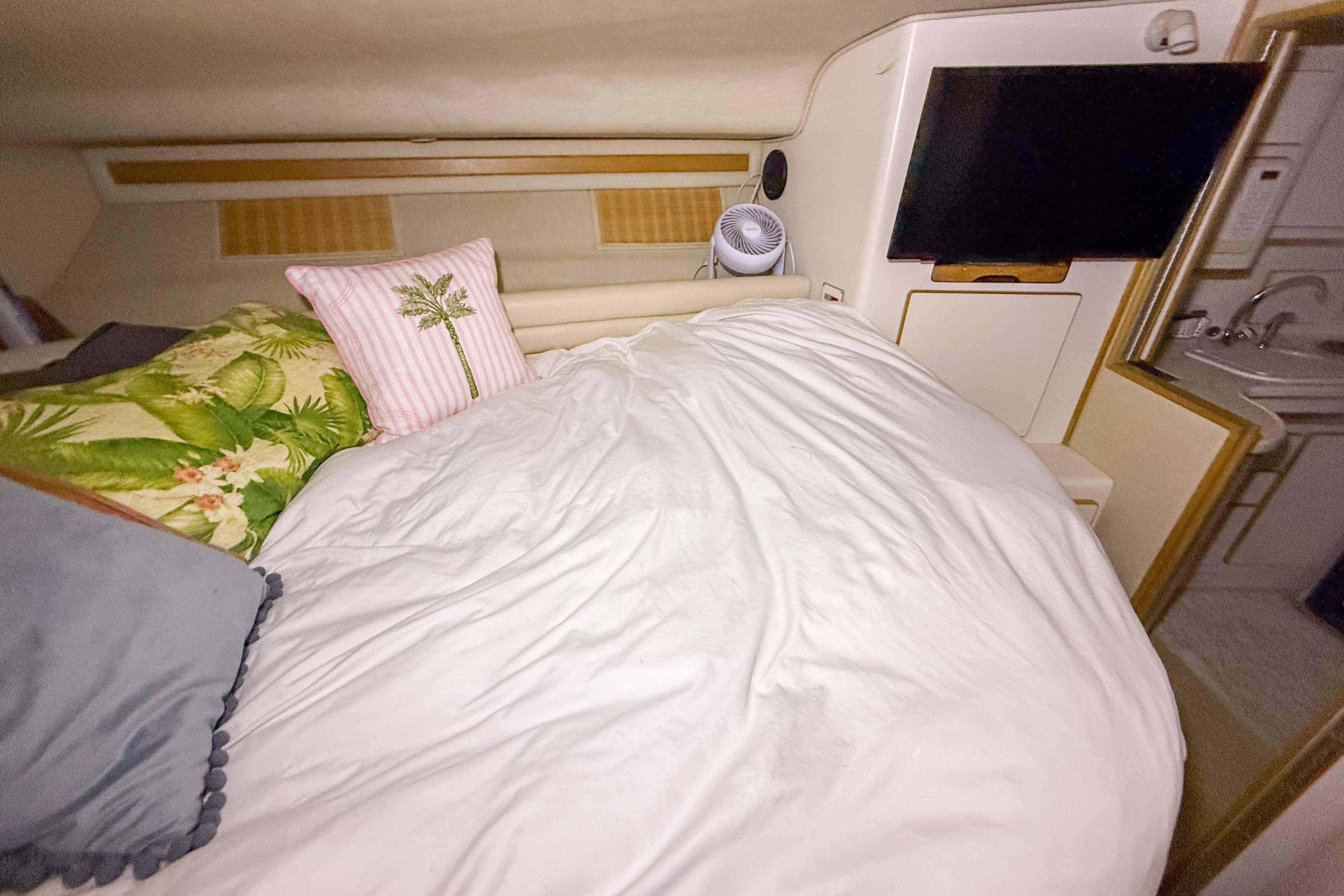 Cozy cabin interior of 1995 Sea Ray 370 Sedan Bridge with bed and TV.