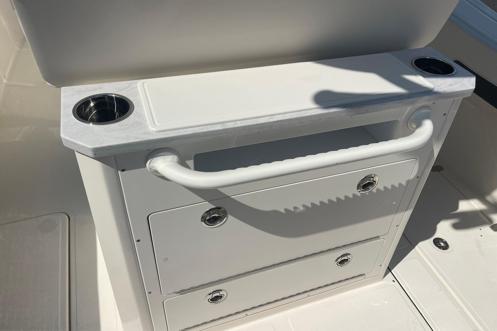 Interior of 2026 Pioneer 250 Pelagic boat with storage drawers and cup holders.