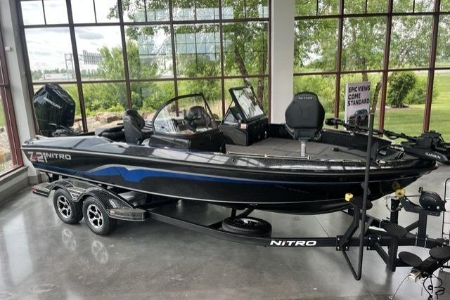 2025 Nitro ZV21 Pro fishing boat displayed indoors with trailer, featuring sleek black design.