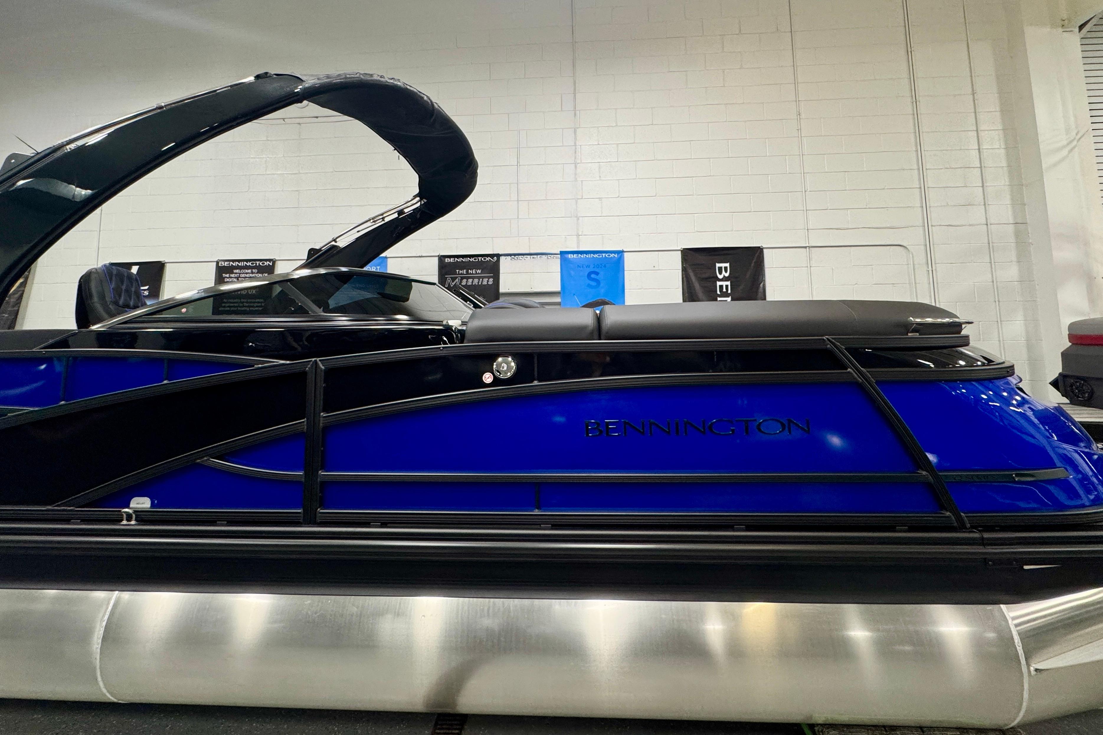 2026 Bennington 25 QSBWASE pontoon boat in showroom, sleek blue design.