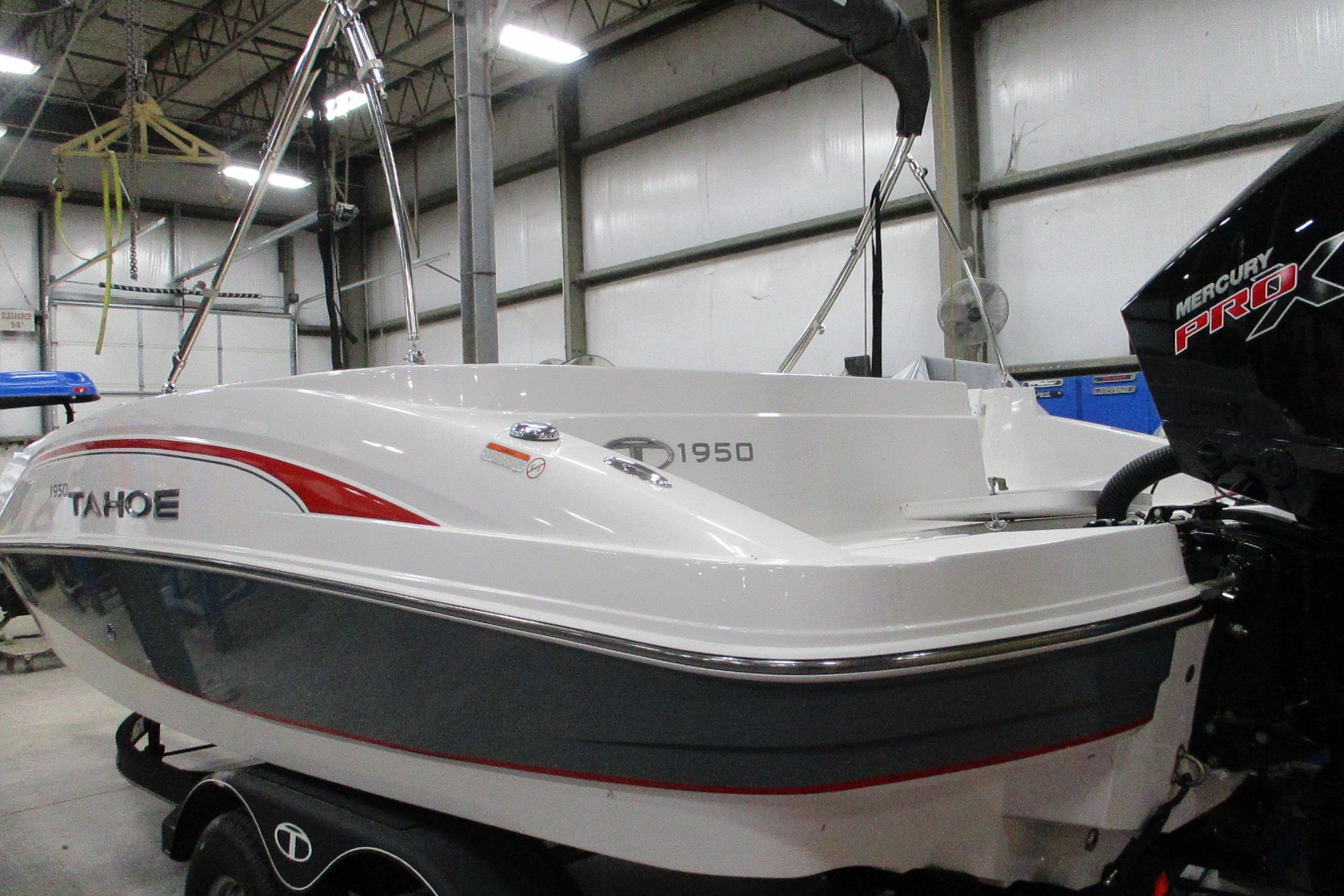 2024 Tahoe 1950 boat in a warehouse, featuring a Mercury Pro outboard motor.