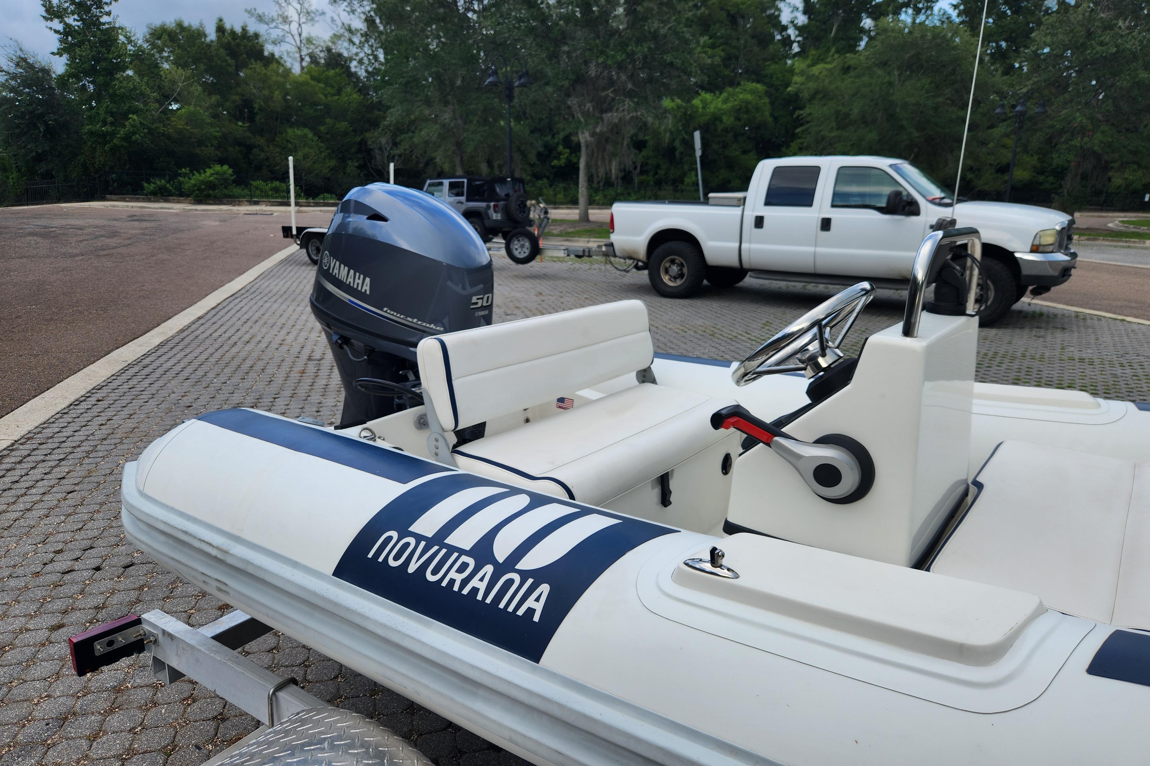 2019 Novurania DL 400 boat with Yamaha engine on trailer, parked near white truck.
