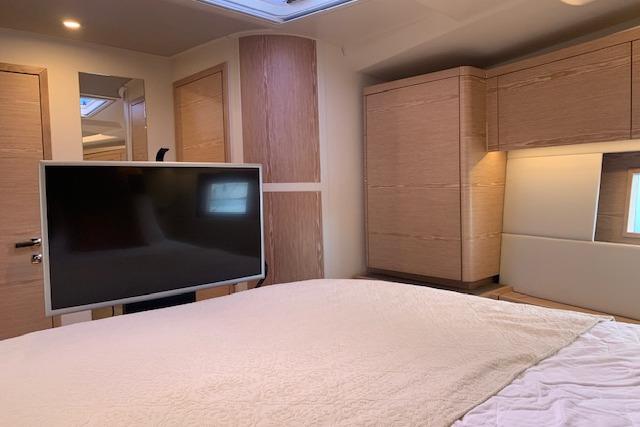 Luxurious interior of 2017 Hanse 588 yacht with modern furnishings and flat-screen TV.