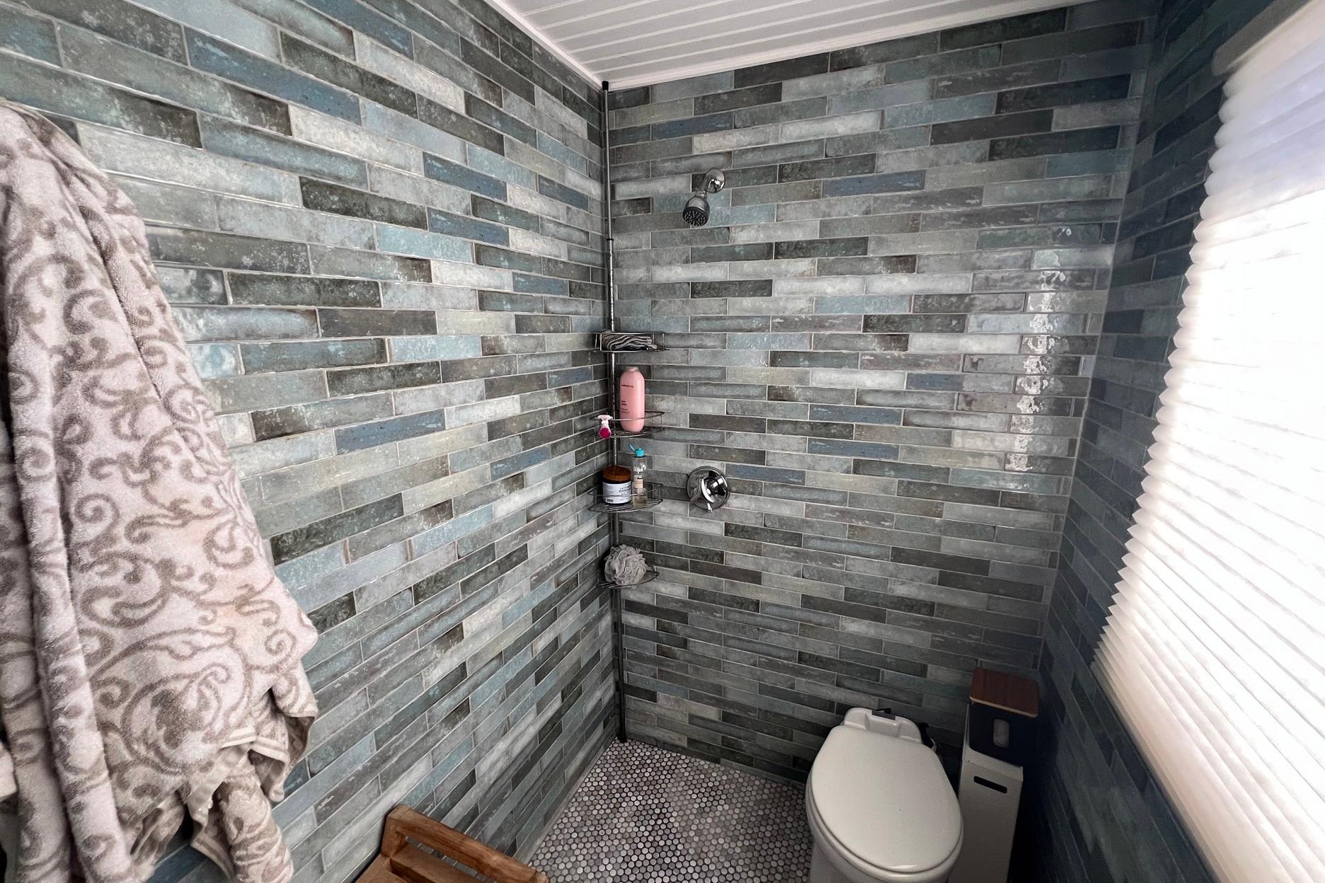 Bathroom interior of a 1993 Sumerset houseboat with modern tiled walls and fixtures.