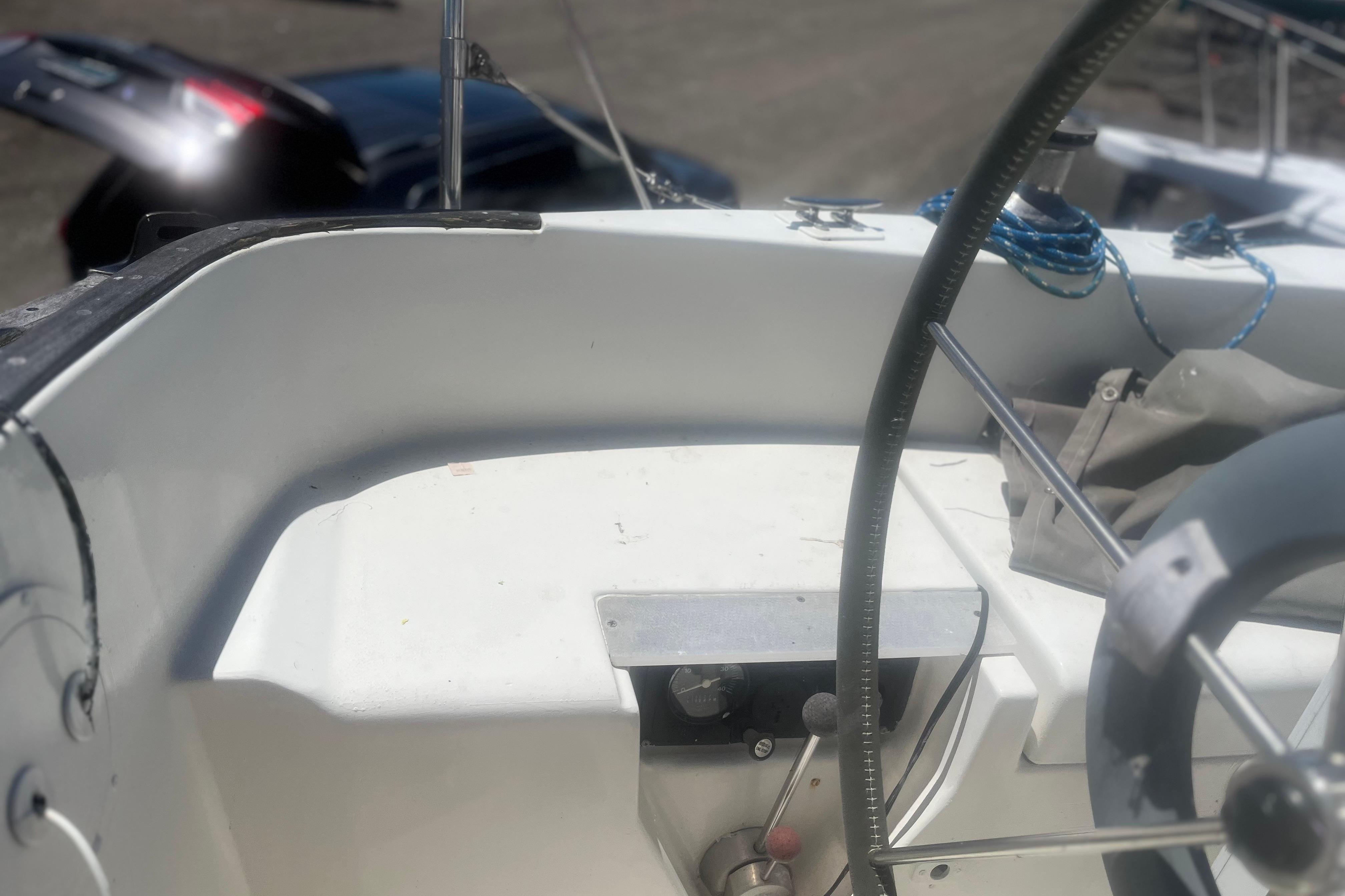 Cockpit of a 1972 C&C 30 sailboat with steering wheel and ropes.
