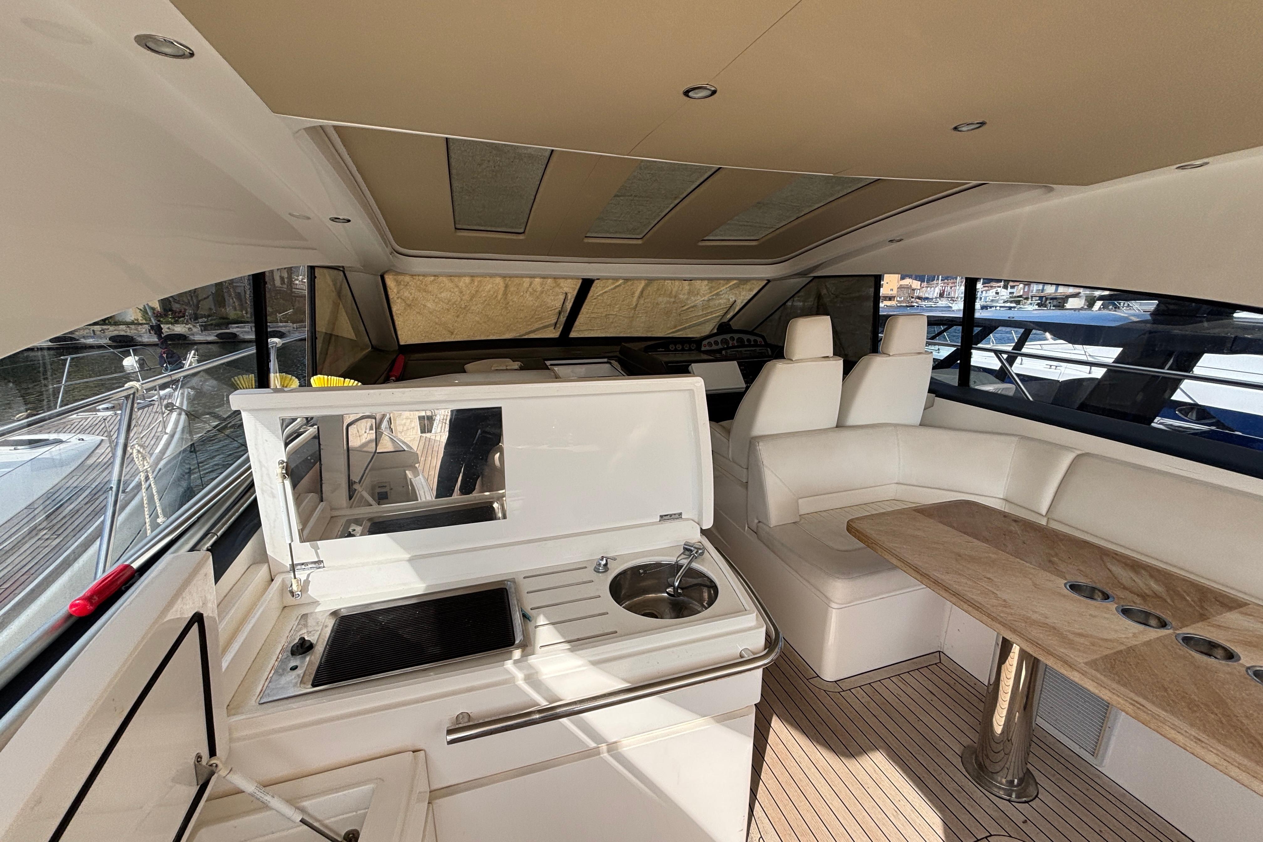 Luxurious interior of 2008 Princess V53 yacht with seating, kitchenette, and table.