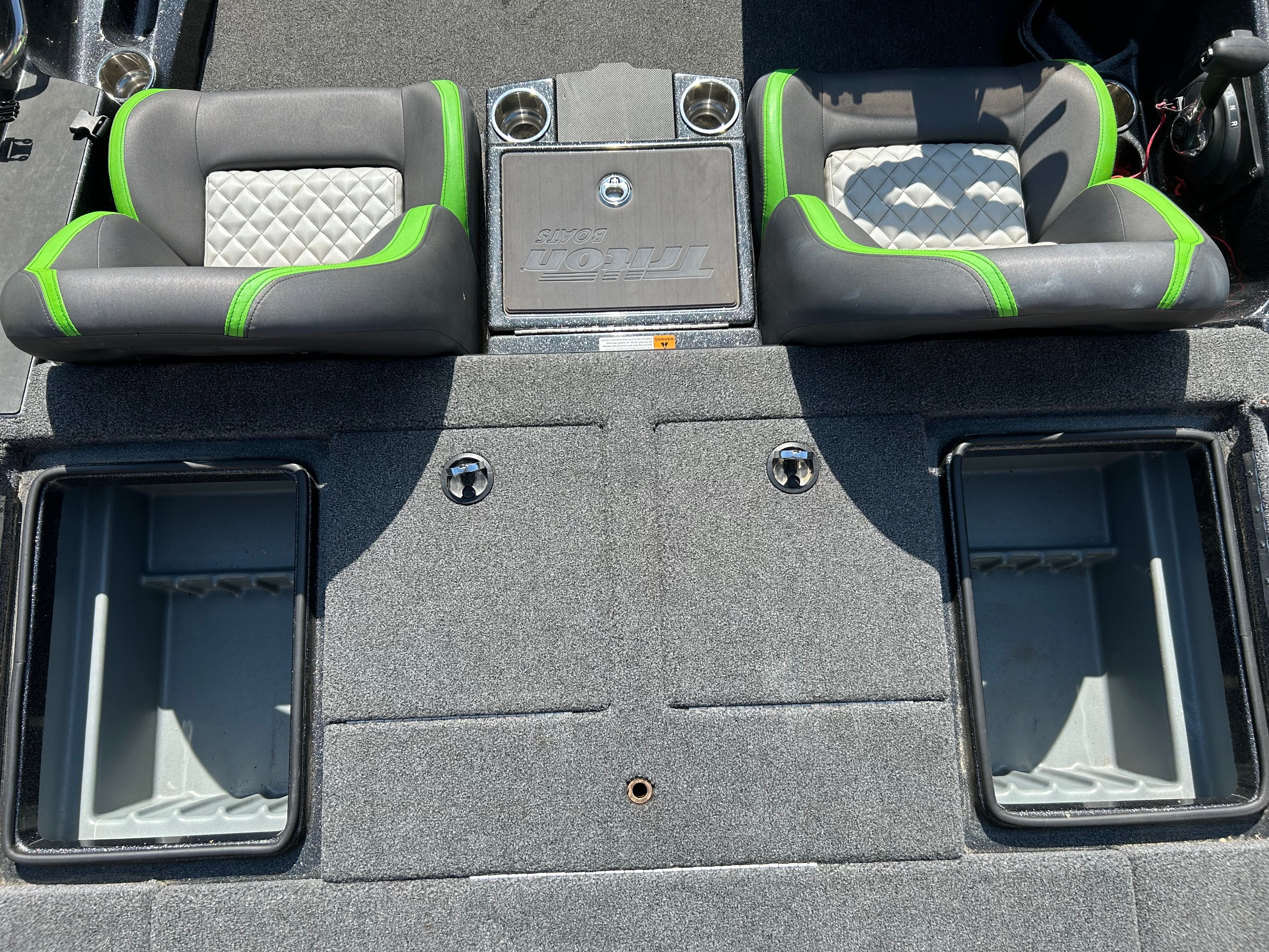 Interior of a Trident 189 TRX boat with gray and green seats and storage compartments.