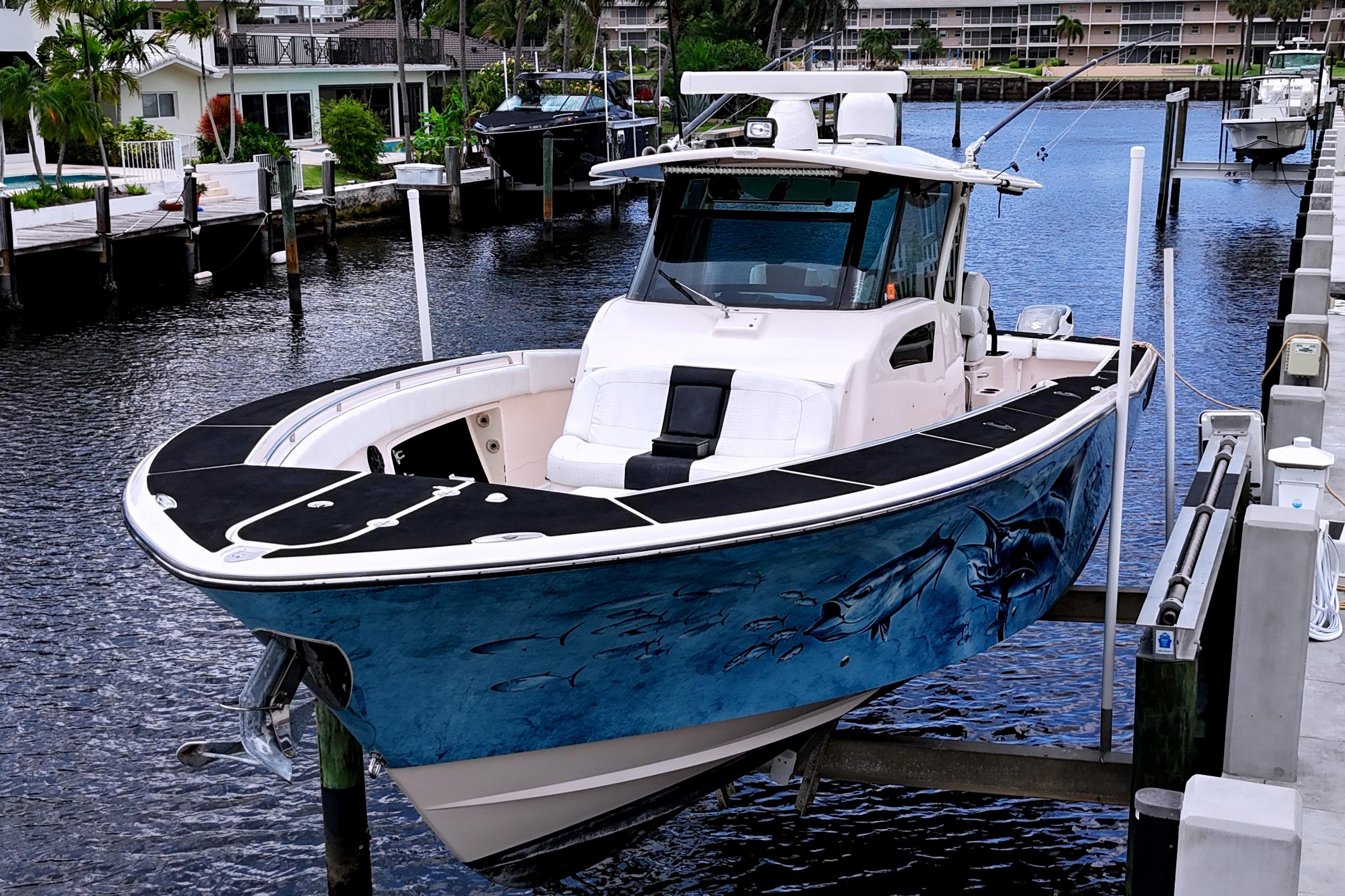 2010 Grady-White Canyon 366 boat docked, featuring marine-themed hull artwork.