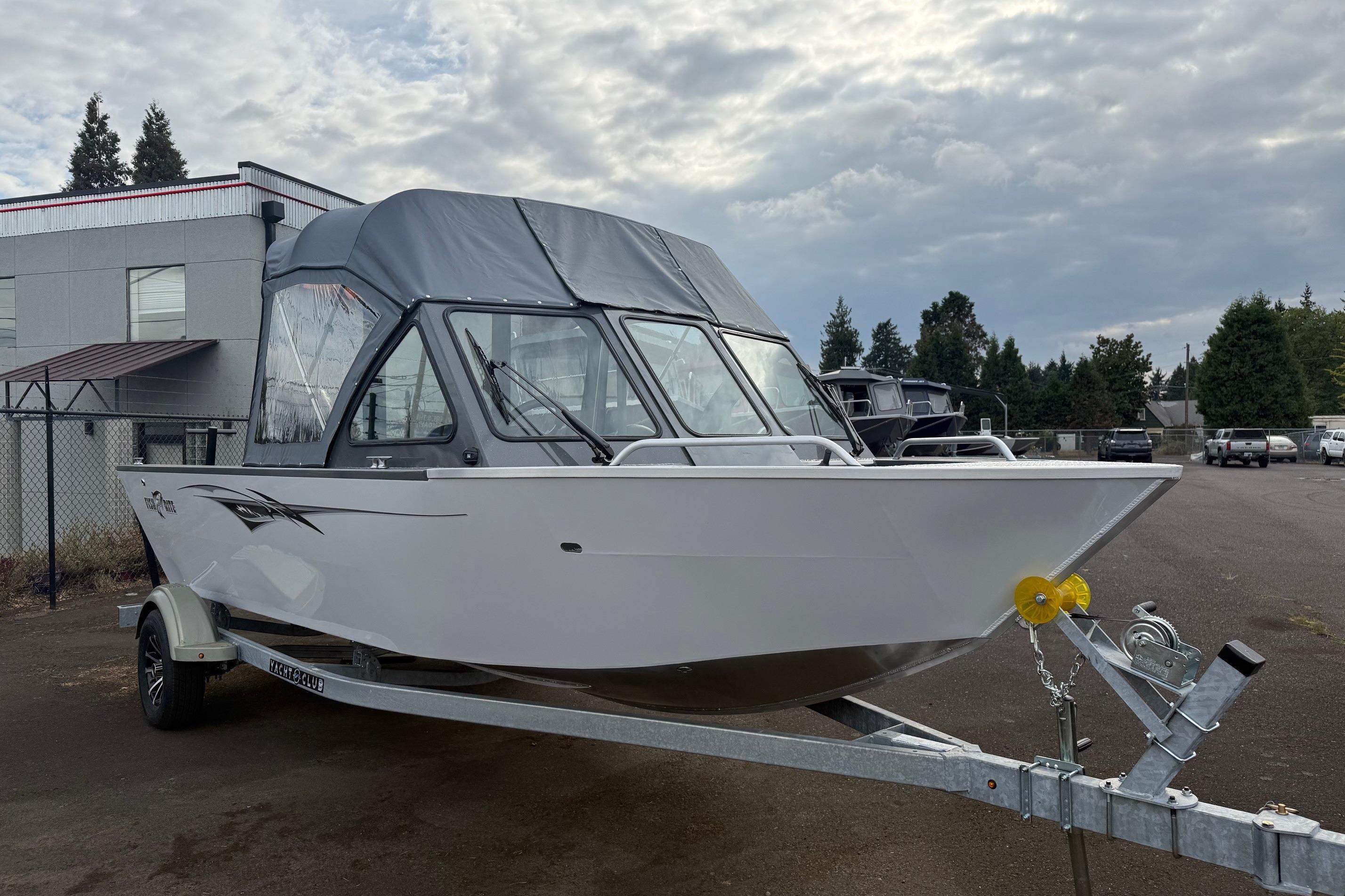 2026 Fish Rite Sportsman 20 boat on trailer, parked outdoors under cloudy sky.