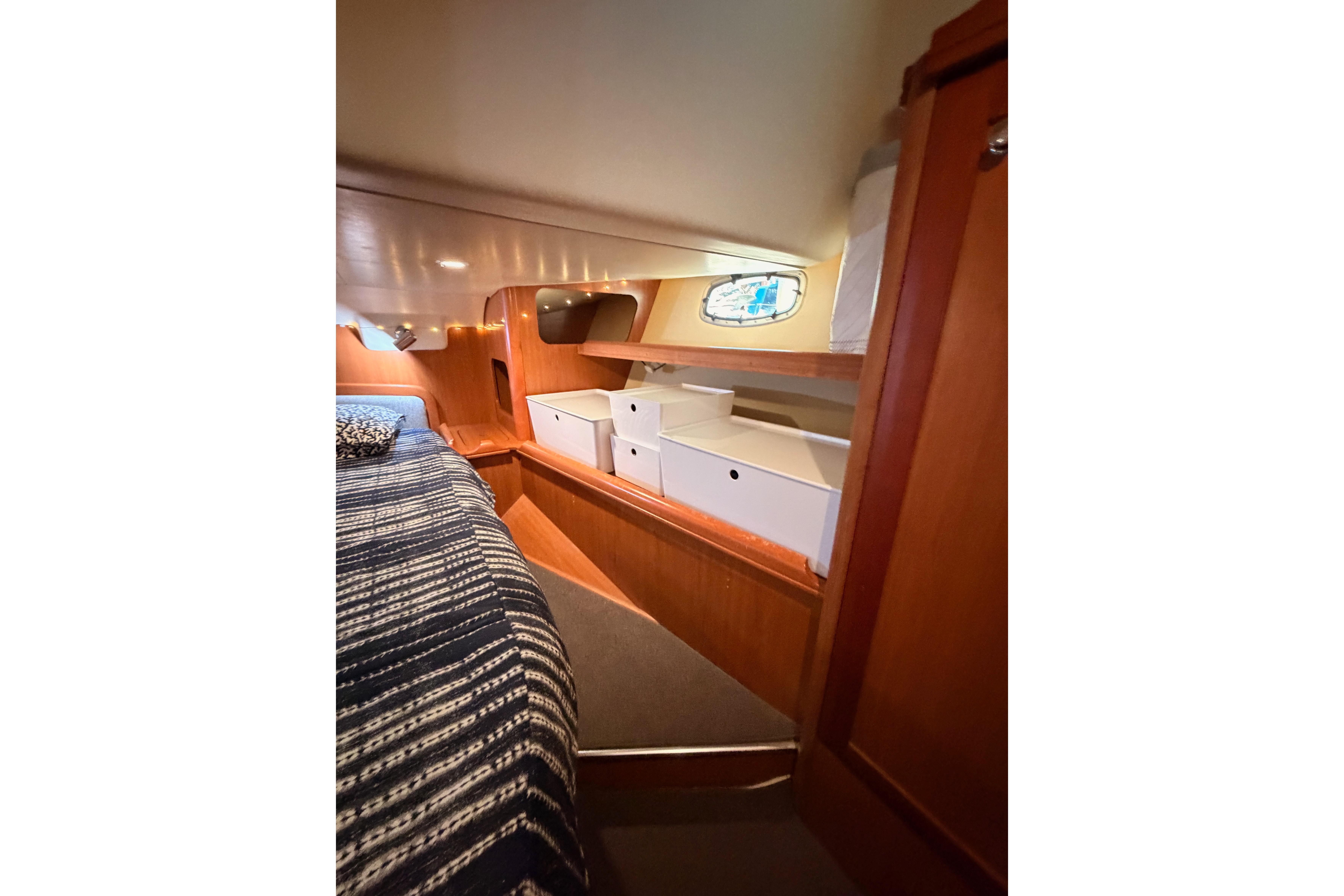Interior cabin of 2008 Hunter 45 Deck Salon with cozy bed and storage.