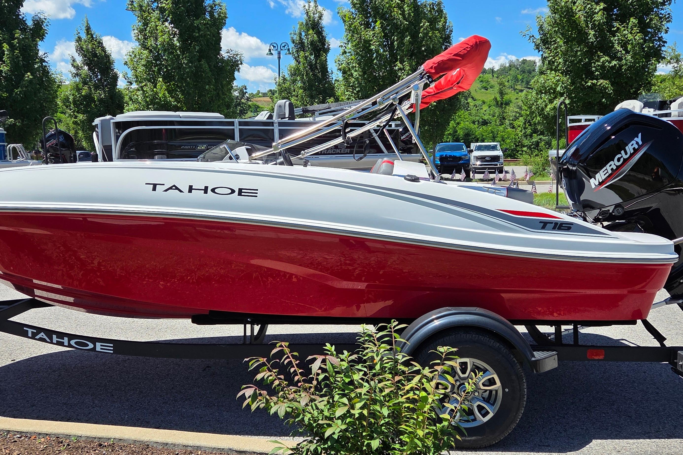 2026 Tahoe T16 boat with red hull on trailer, parked outdoors.