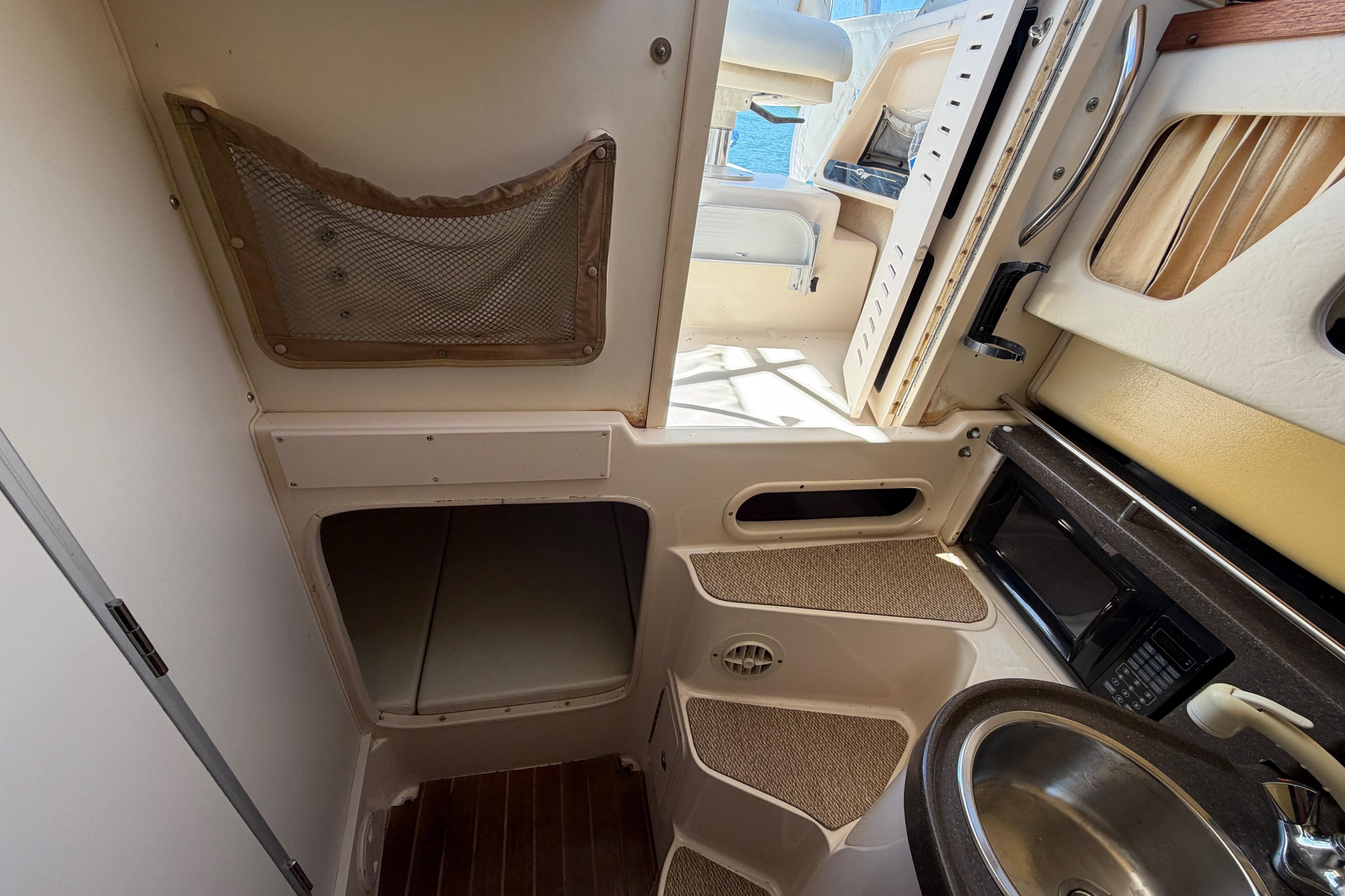 2006 Grady-White Sailfish 282 cabin interior with kitchenette and storage space.