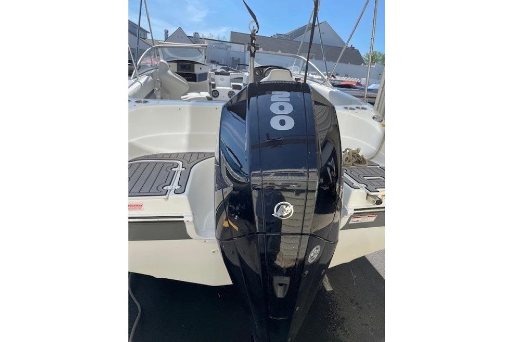 2023 Hurricane SunDeck 217 OB boat with powerful outboard motor in marina setting.