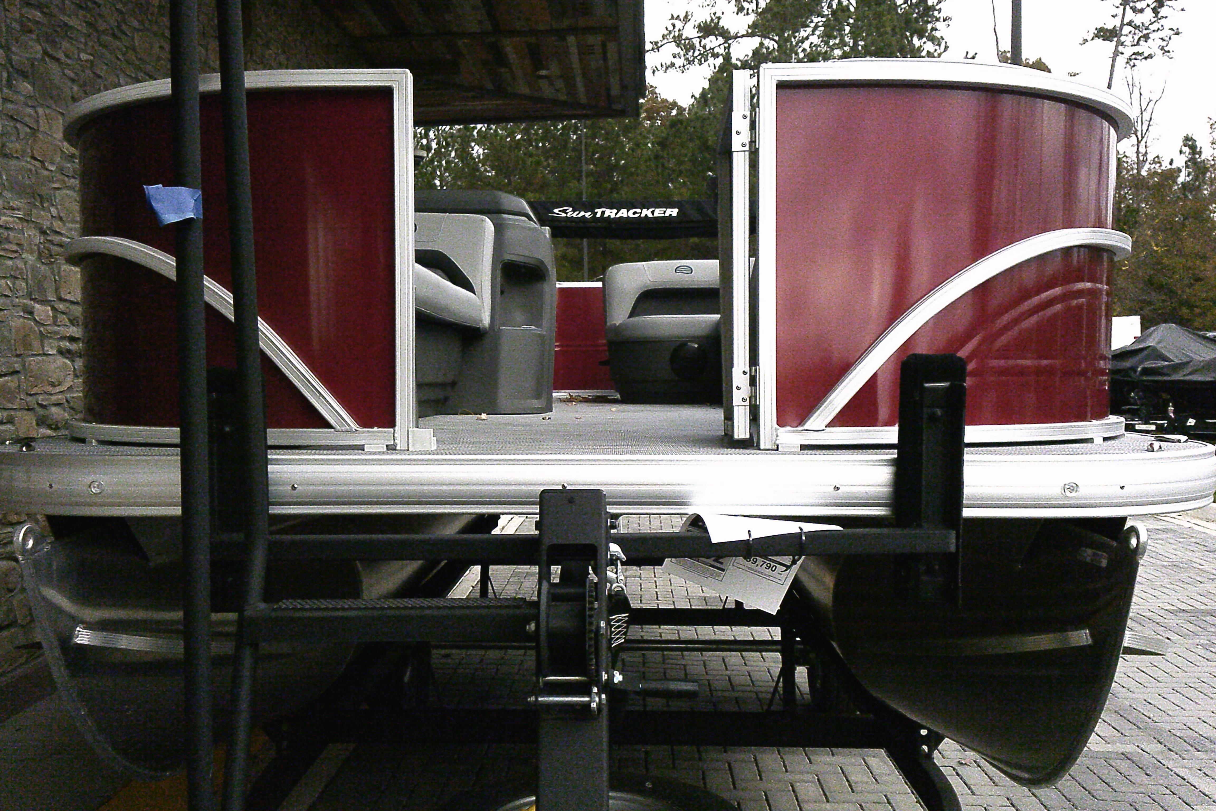 2026 Sun Tracker Party Barge 18 DLX pontoon boat with red exterior on trailer.