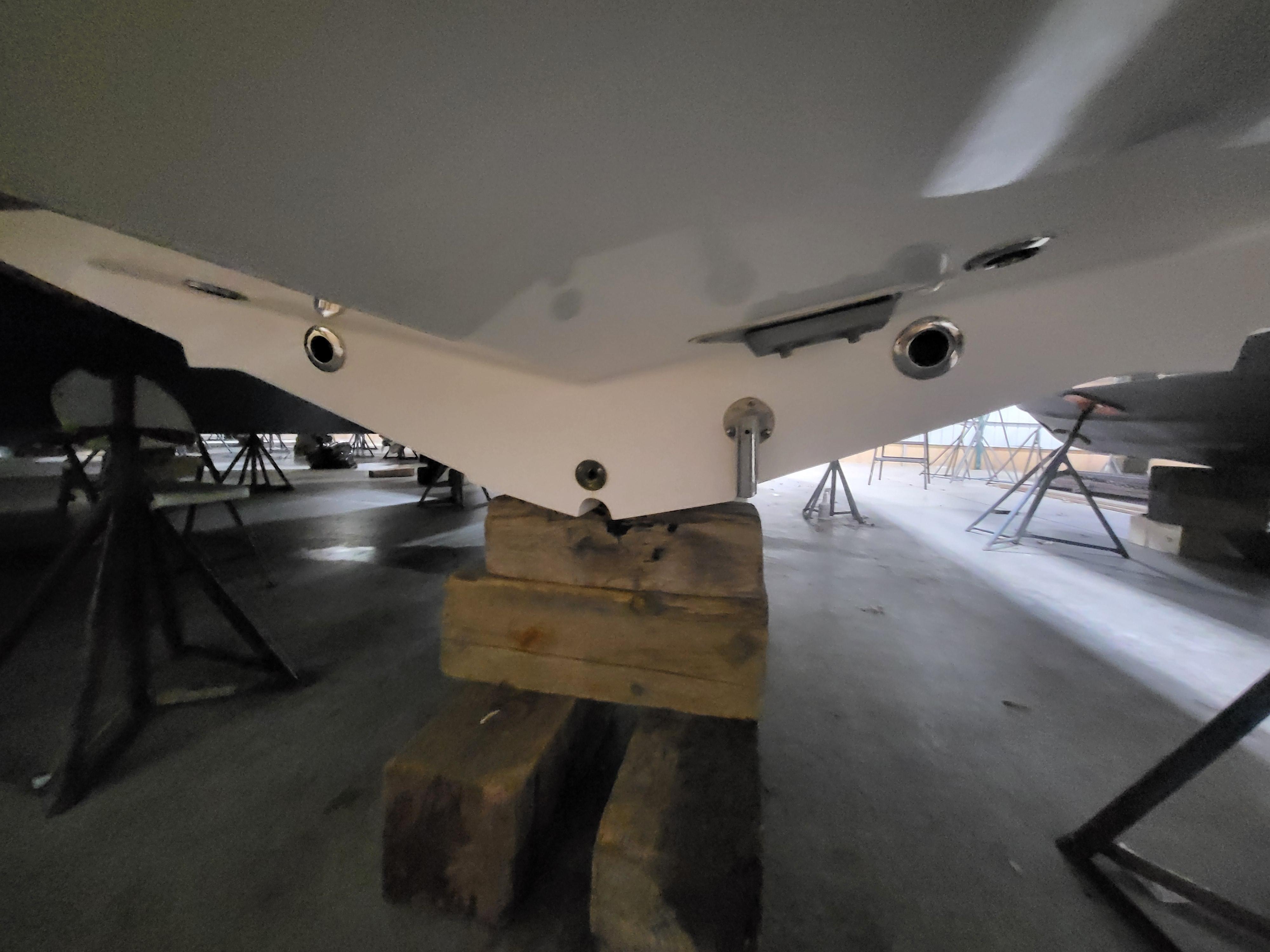 2022 Fountain 38 SC boat hull on wooden blocks in storage.