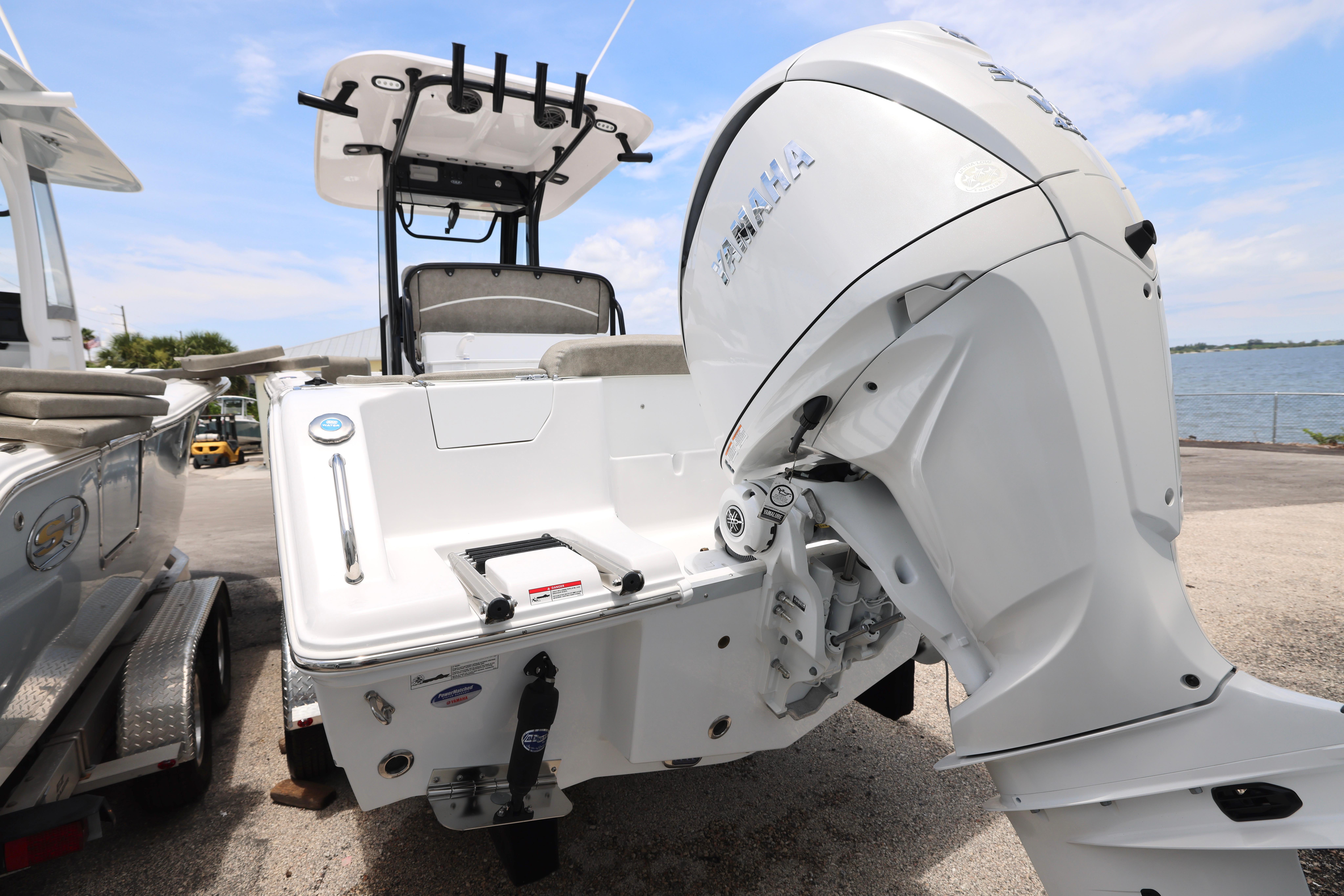 2026 Sea Hunt Ultra 245 SE boat with Yamaha outboard motor, docked near water.