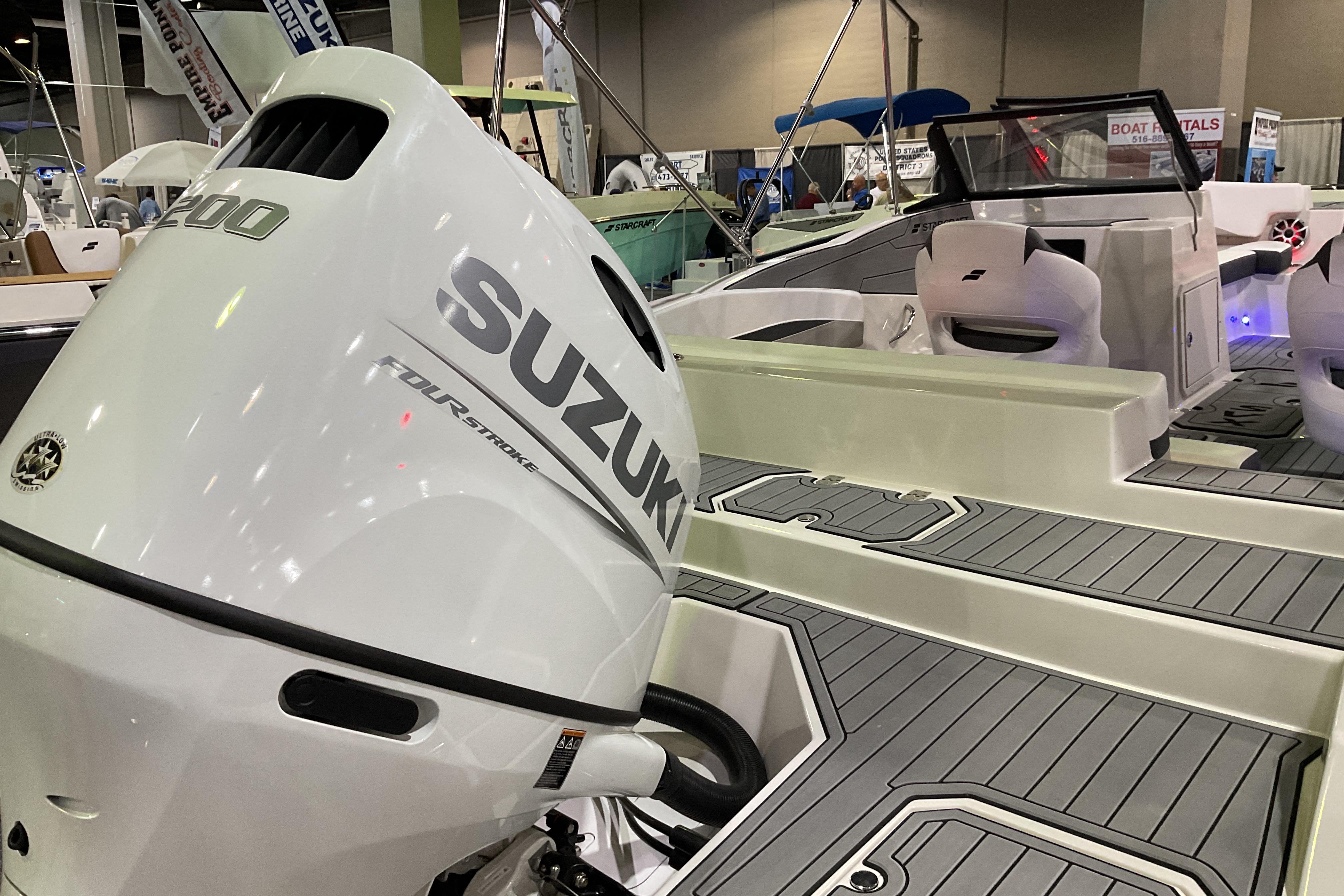 2026 Starcraft SVX 210 DC OB boat with Suzuki outboard motor at a boat show.
