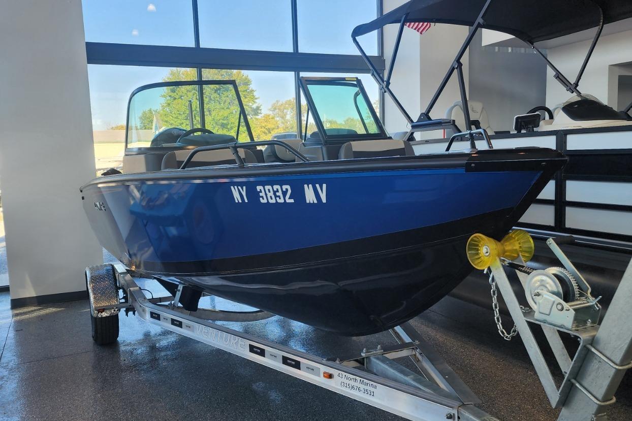 2023 Lowe boat on trailer in showroom, blue exterior, registration NY 3832 MV.
