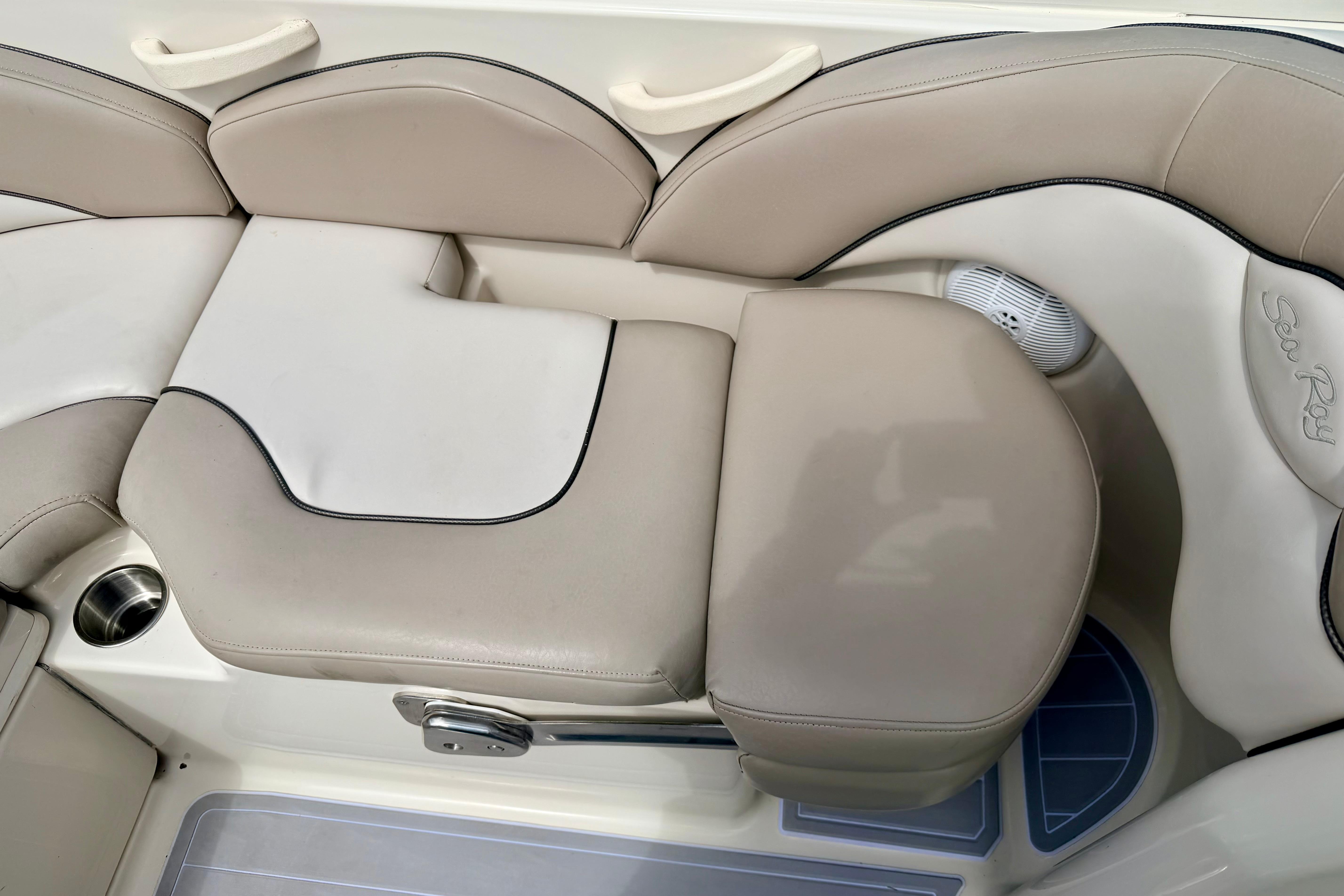 2003 Sea Ray 200 Sundeck interior seating with beige upholstery and cup holder.