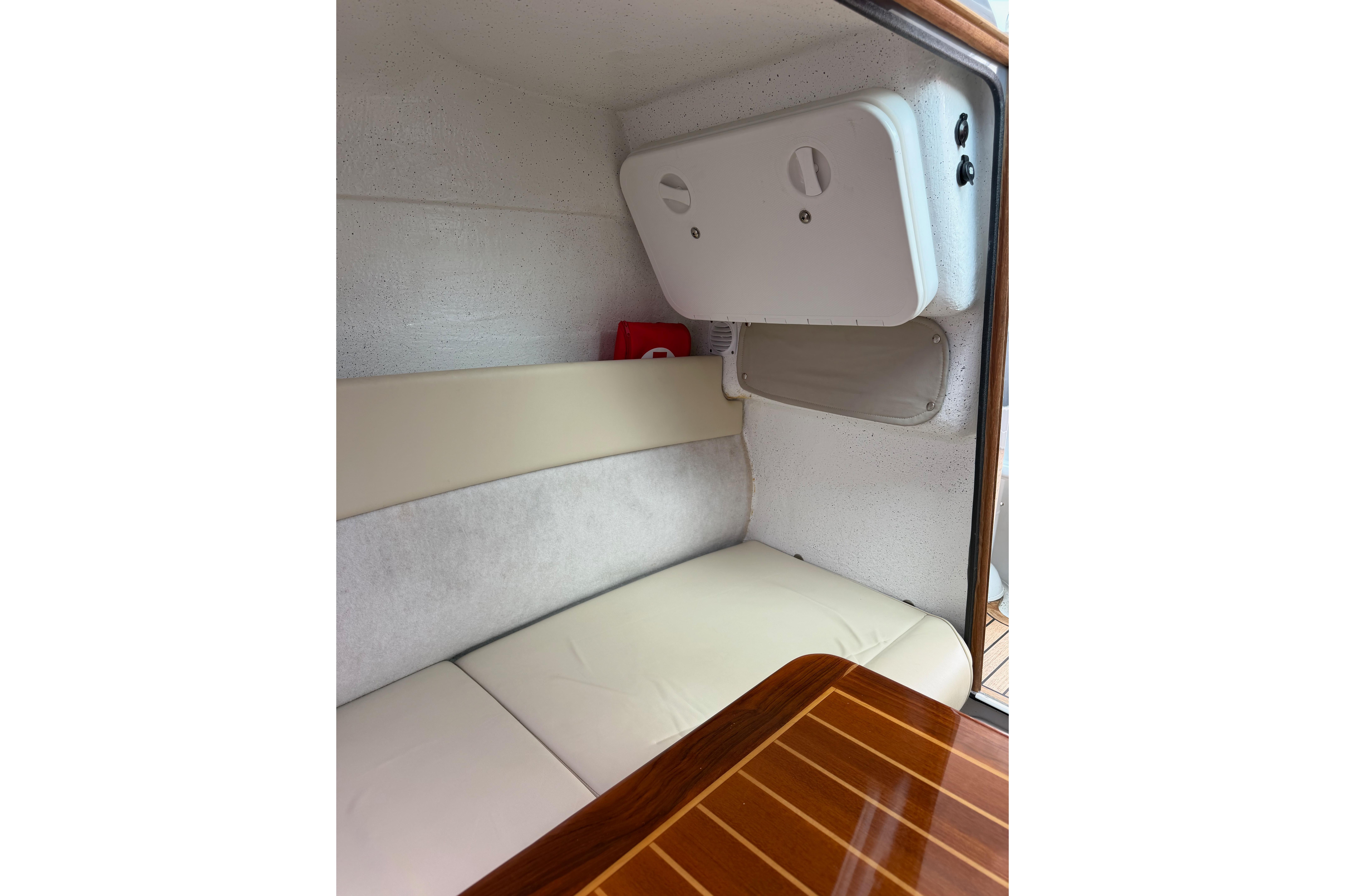 Interior of 2016 Protector Targa 30 boat with cushioned seating and wooden table.