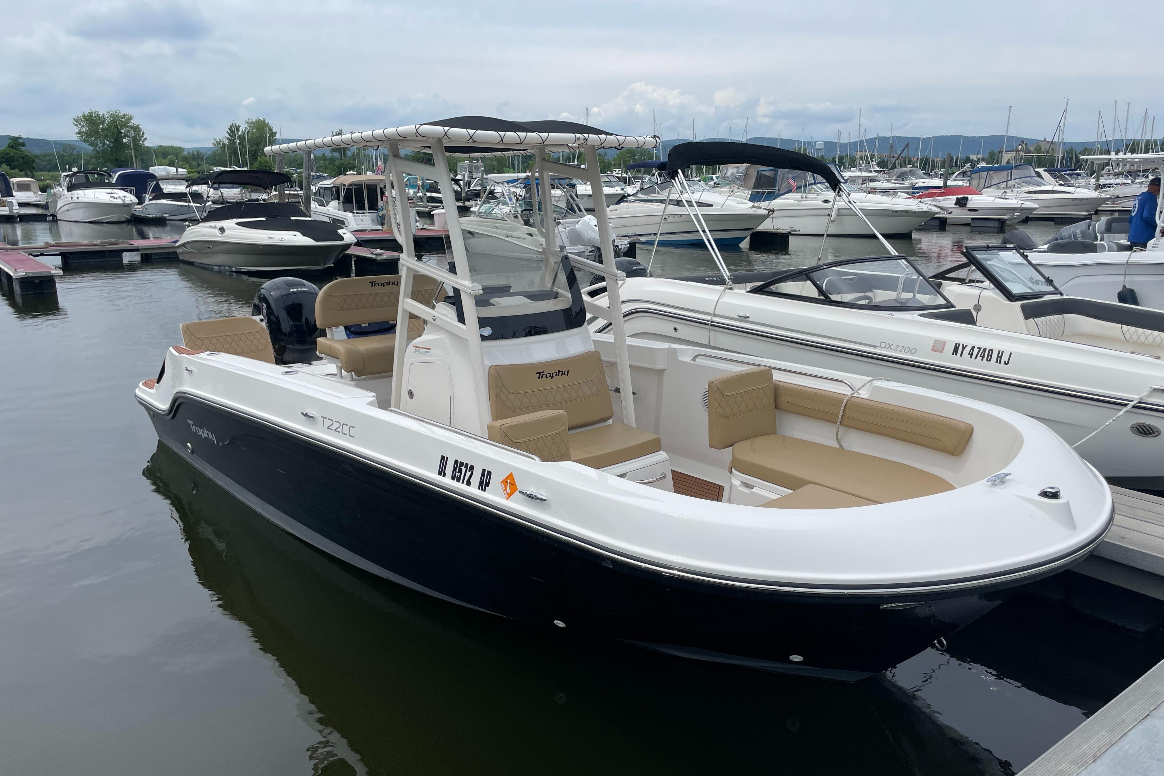 2024 Trophy CC22 boat docked at marina, featuring sleek design and comfortable seating.