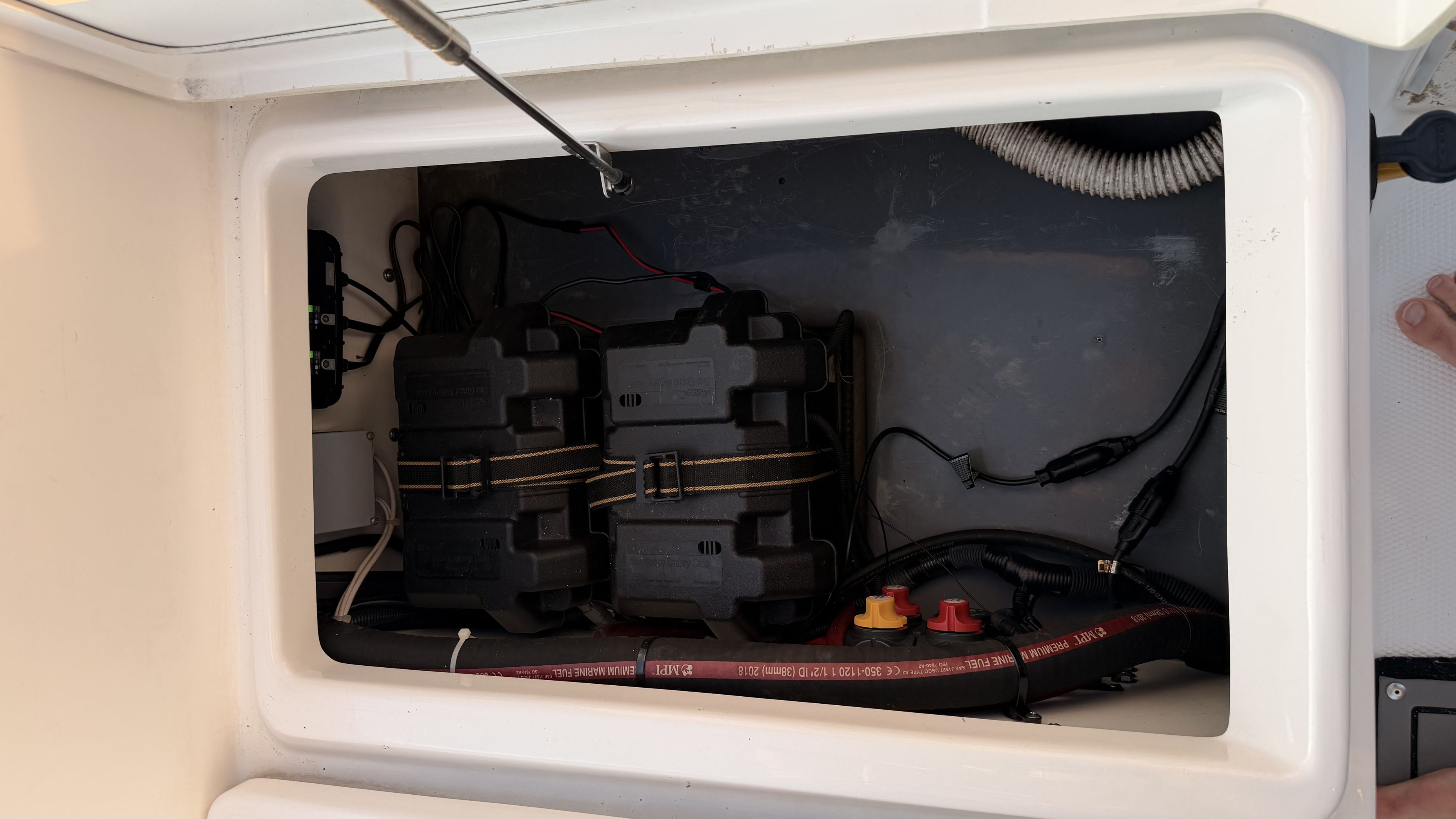 Battery compartment of a 2019 Yamaha 190 FSH Sport with two batteries and wiring.