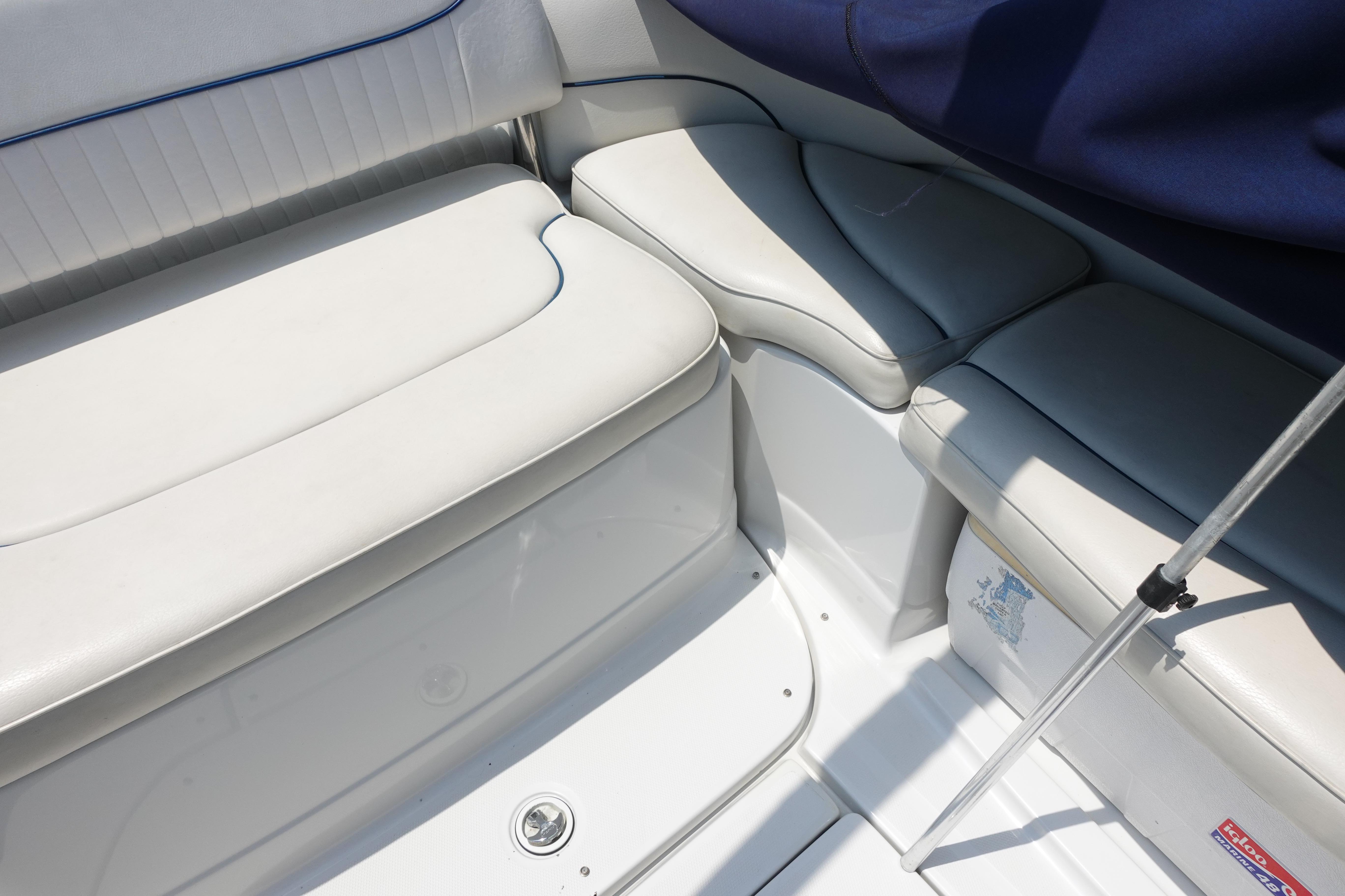 2004 Crownline 240 EX boat interior with white cushioned seating and blue accents.