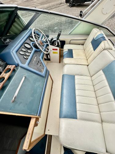 1987 Sea Ray 270 Sundancer interior with blue and white seating and control panel.