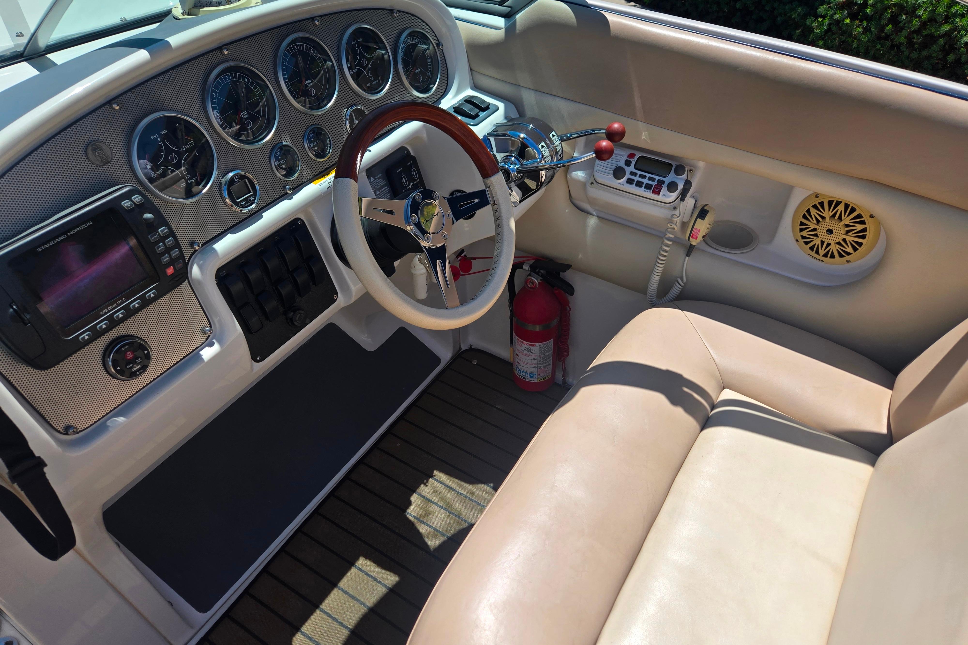 Interior of 2002 Chris-Craft Launch 28 GT I/O boat with steering wheel and dashboard controls.