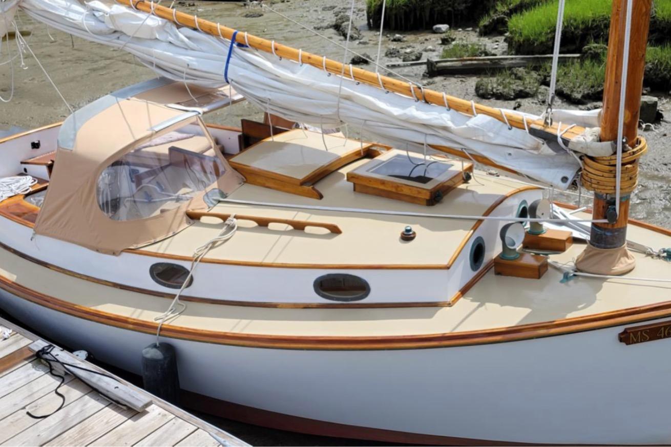 Vintage 1978 Cape Cod Catboat, Ted Brewer model, docked with sails furled.