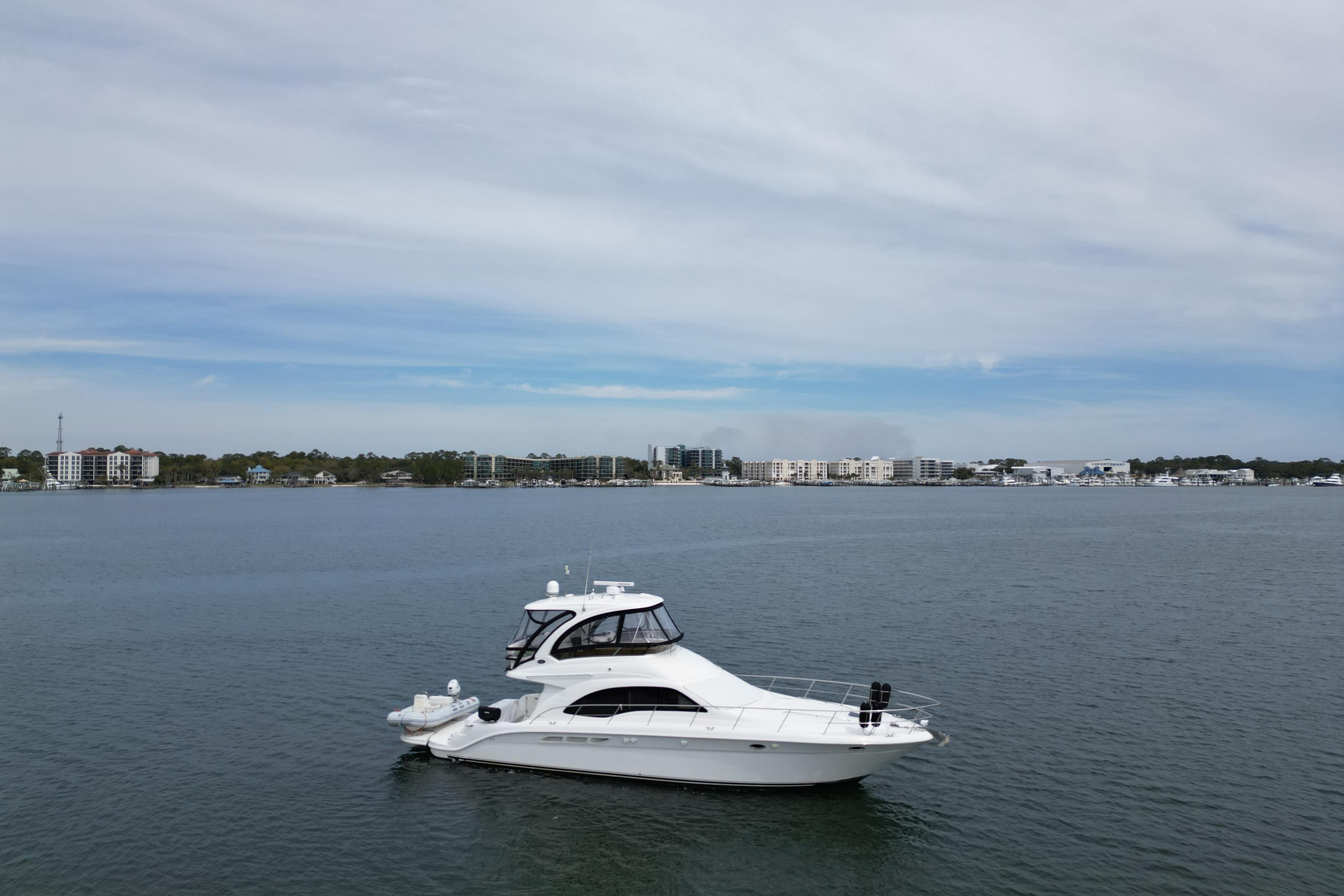2007 Sea Ray 52 Sedan Bridge yacht cruising on calm waters under a cloudy sky.