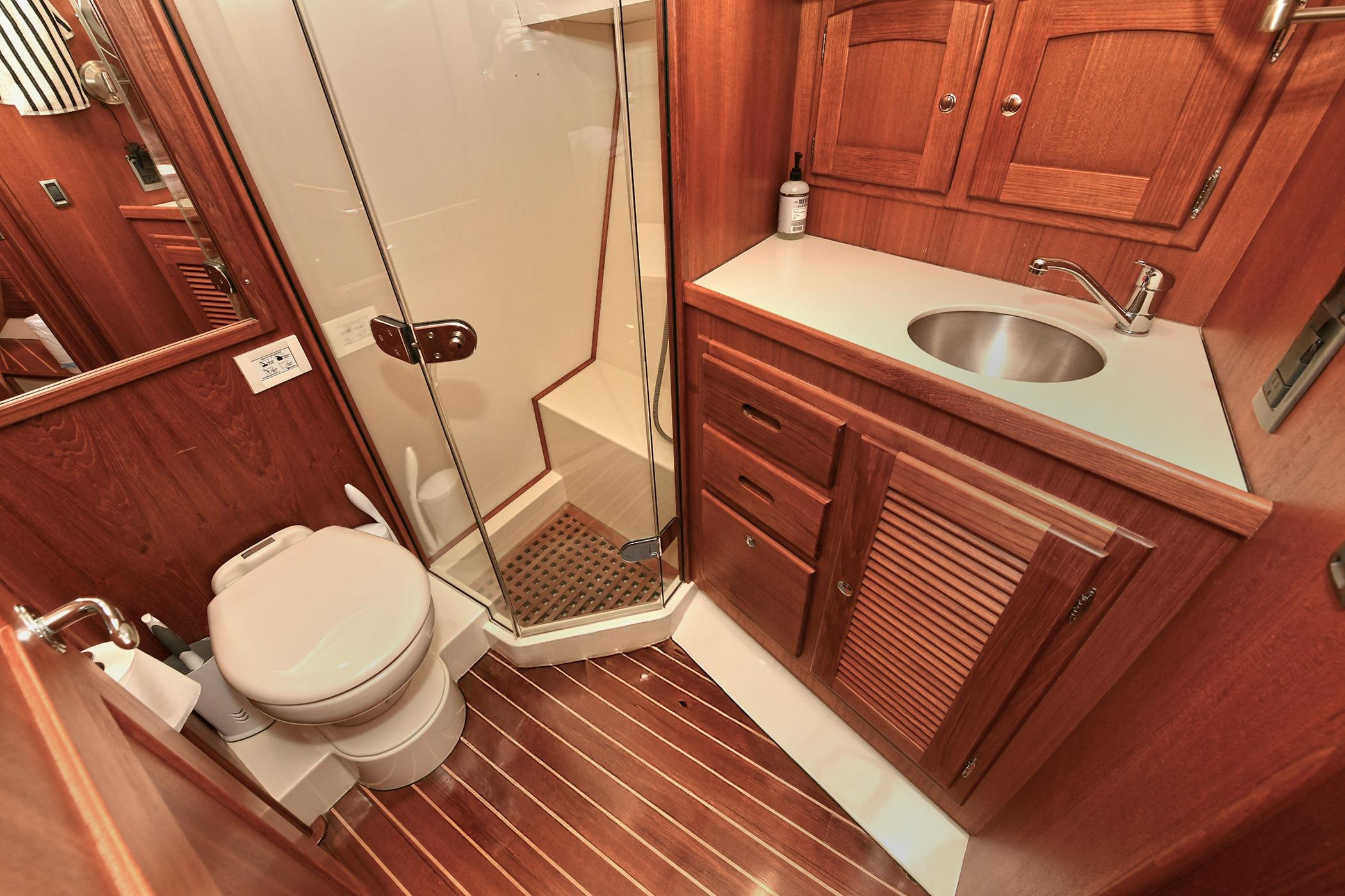 Luxurious 2005 San Juan Downeast Express yacht bathroom with wood accents and modern fixtures.