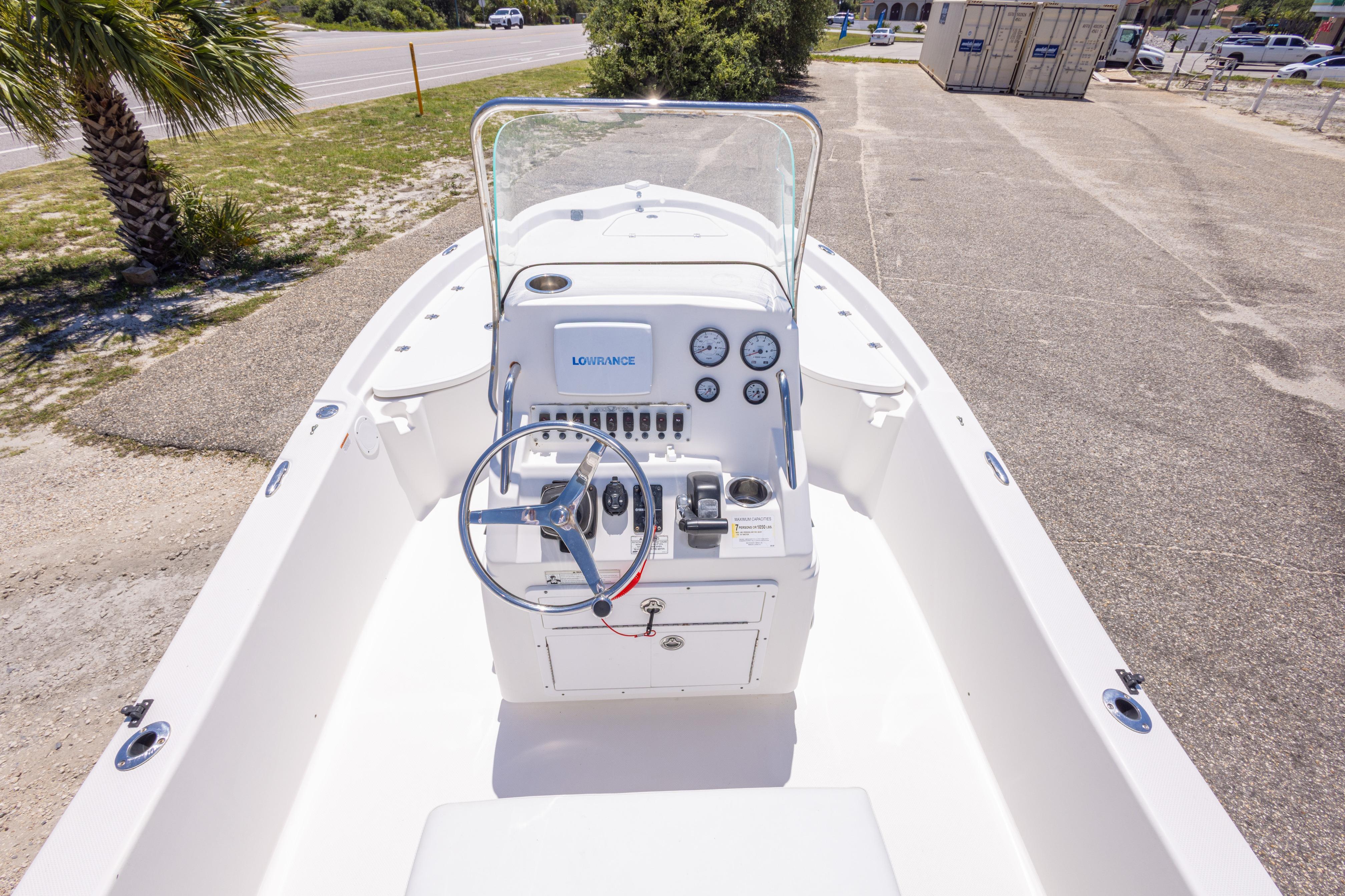 2011 Sea Fox 200XT boat dashboard with steering wheel and gauges, parked outdoors.